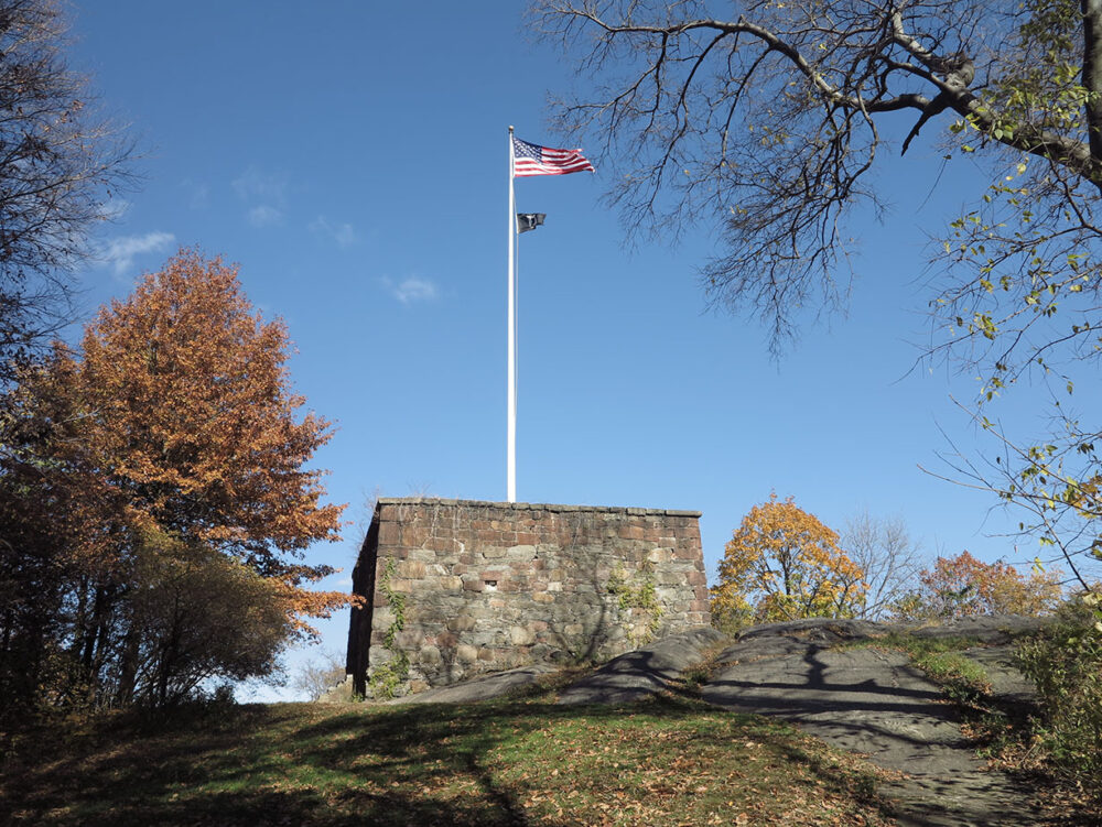 The flag of the United States flies high on the flagpole of the Blockhouse