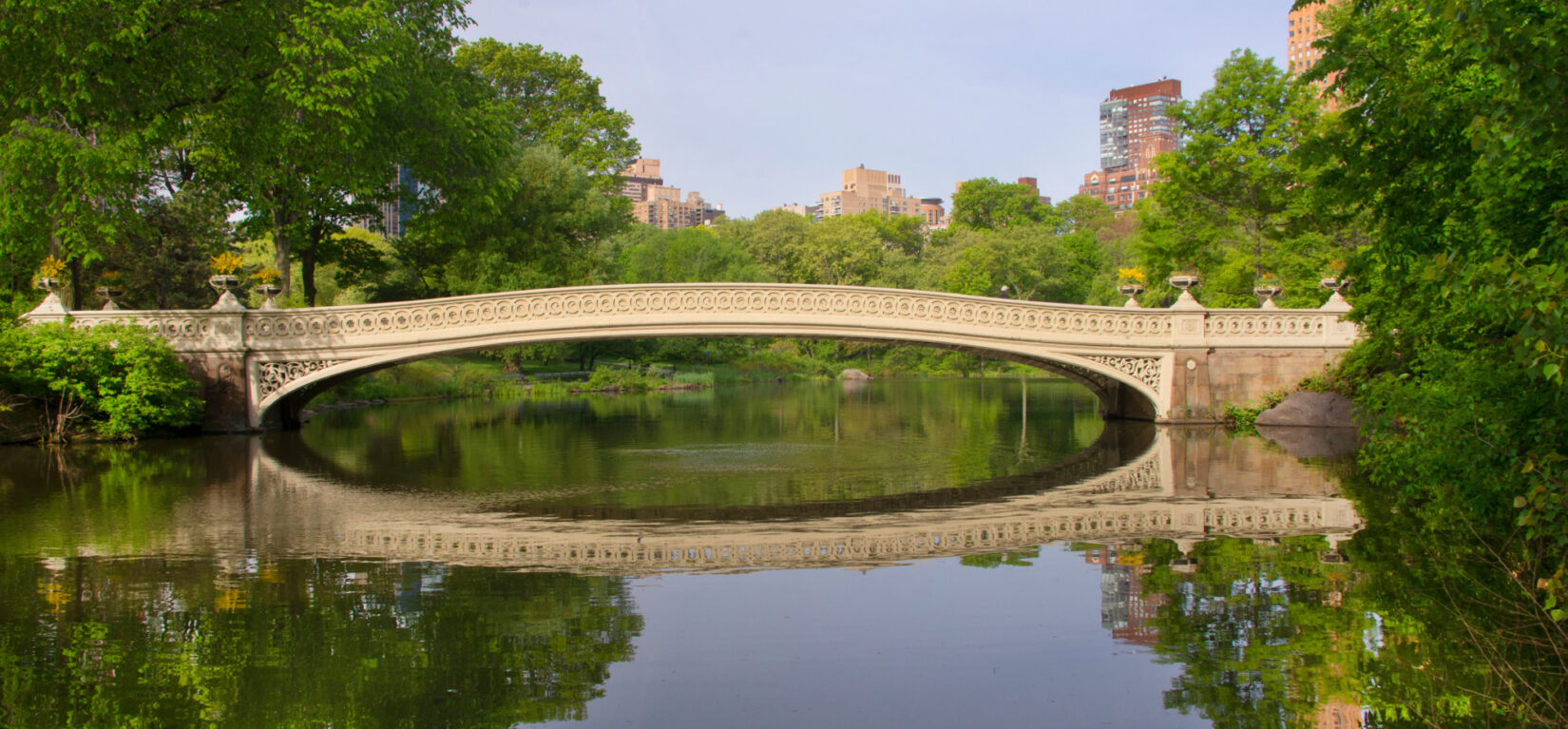 The Bow Bridge and its image mirrored on the stillness of the Lake