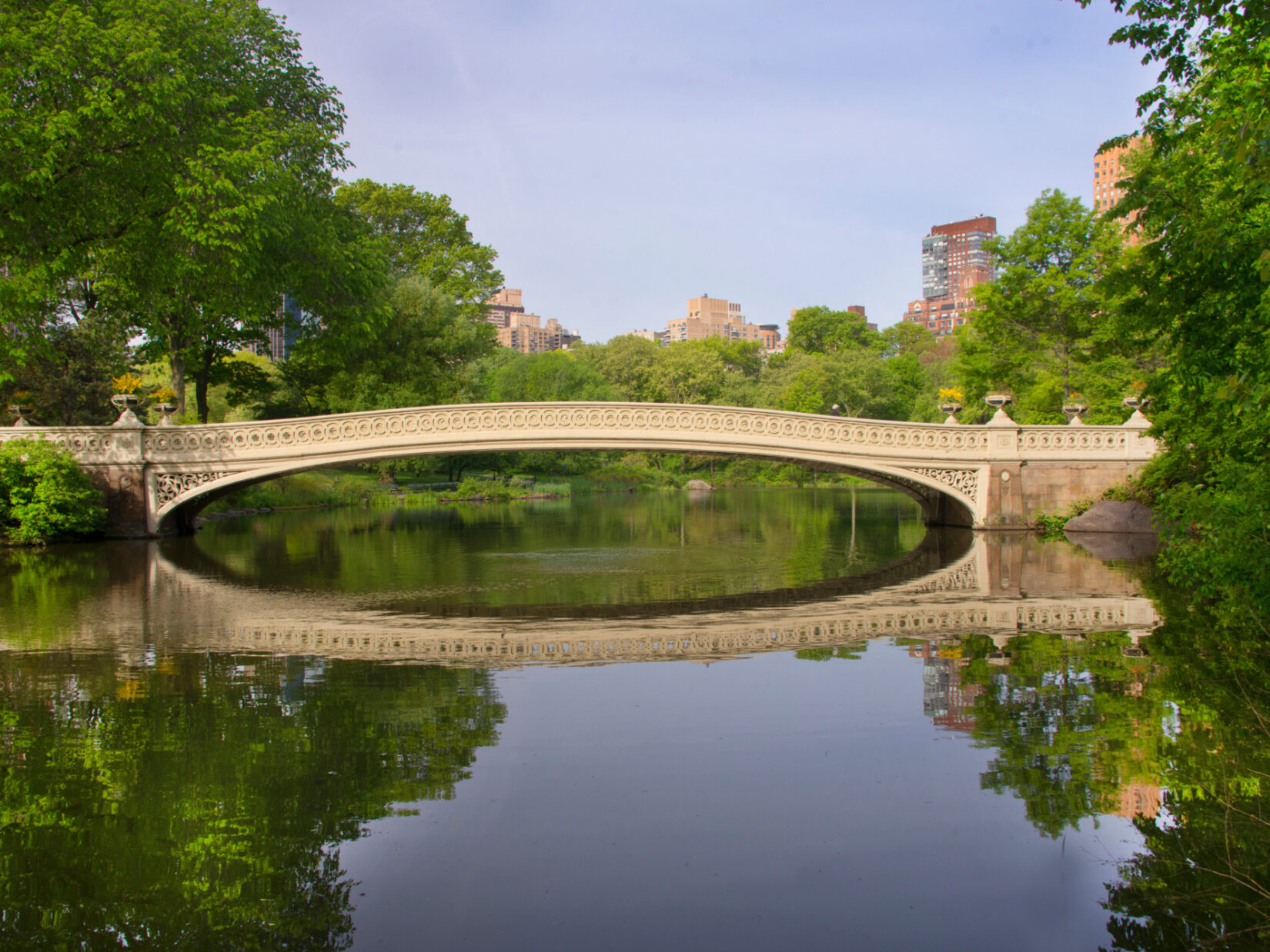 The Bow Bridge and its image mirrored on the stillness of the Lake