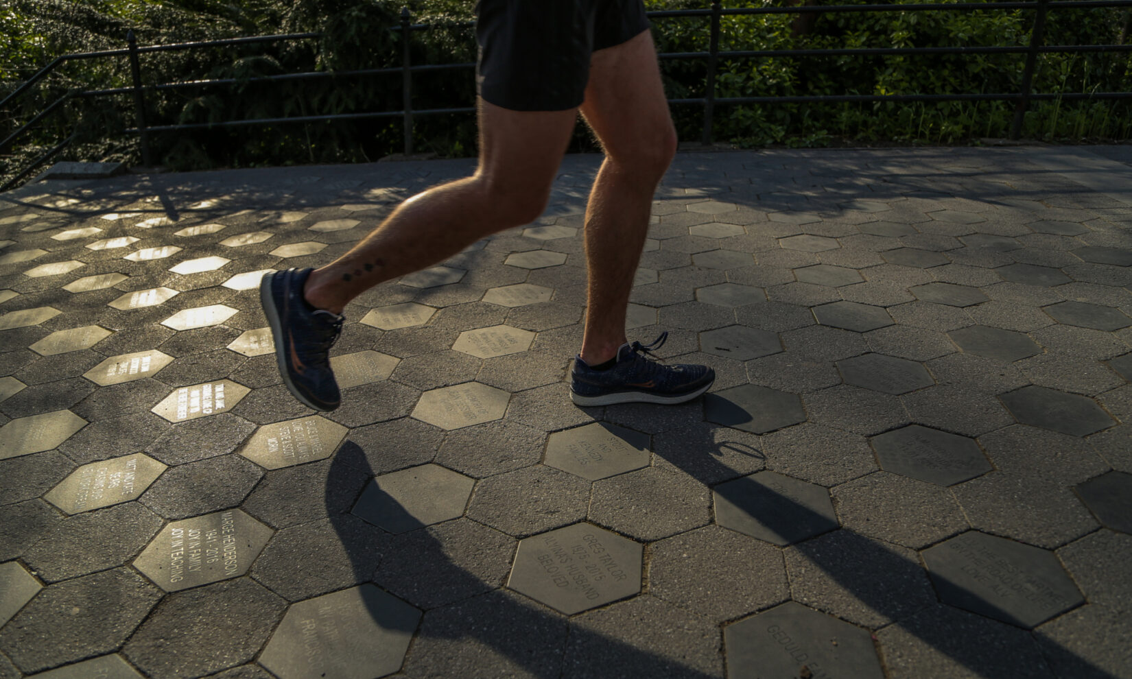 A runner jogs over the memorial stones of Gilder Run, shot in twilight