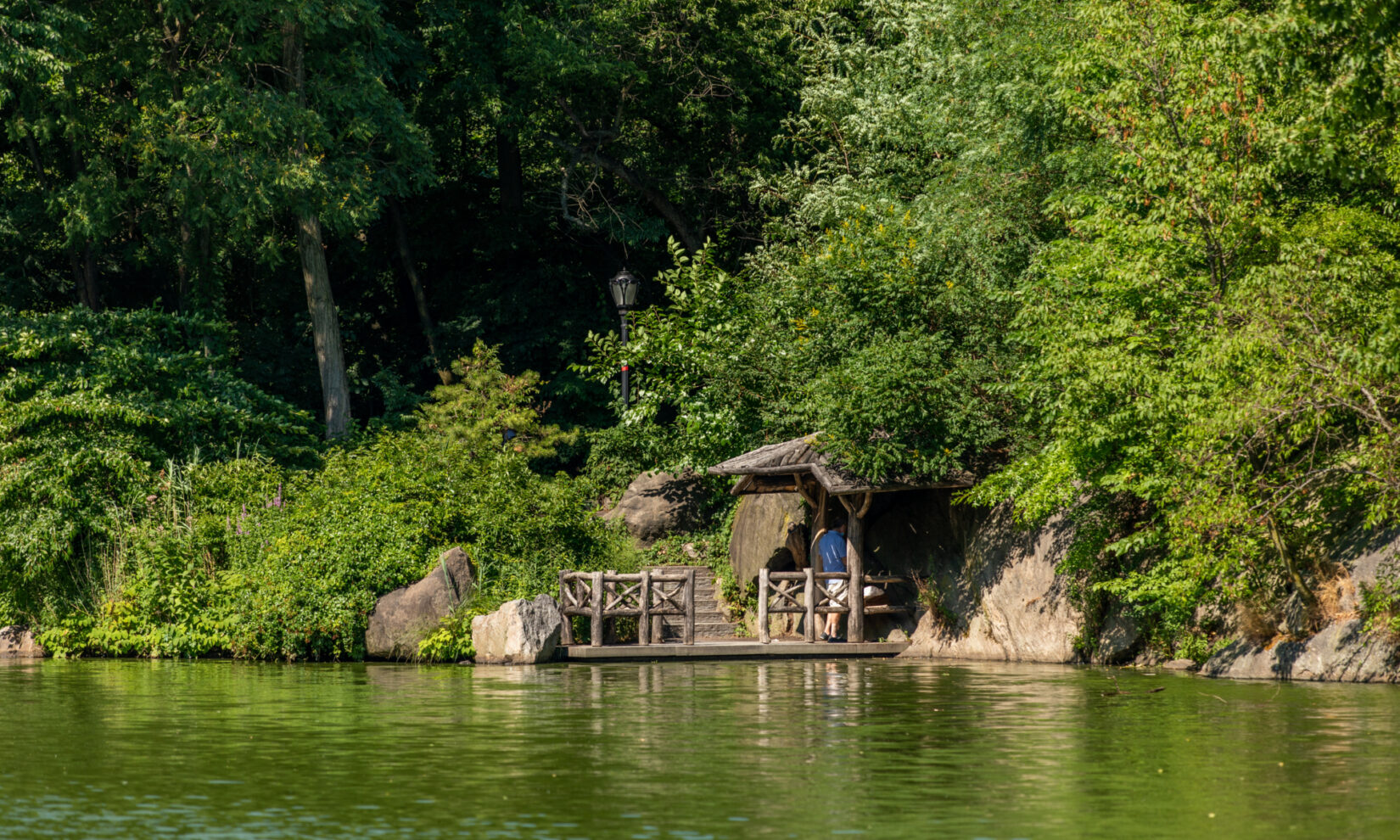 The landing is reflected in the water of the Lake with tall trees as a backdrop.