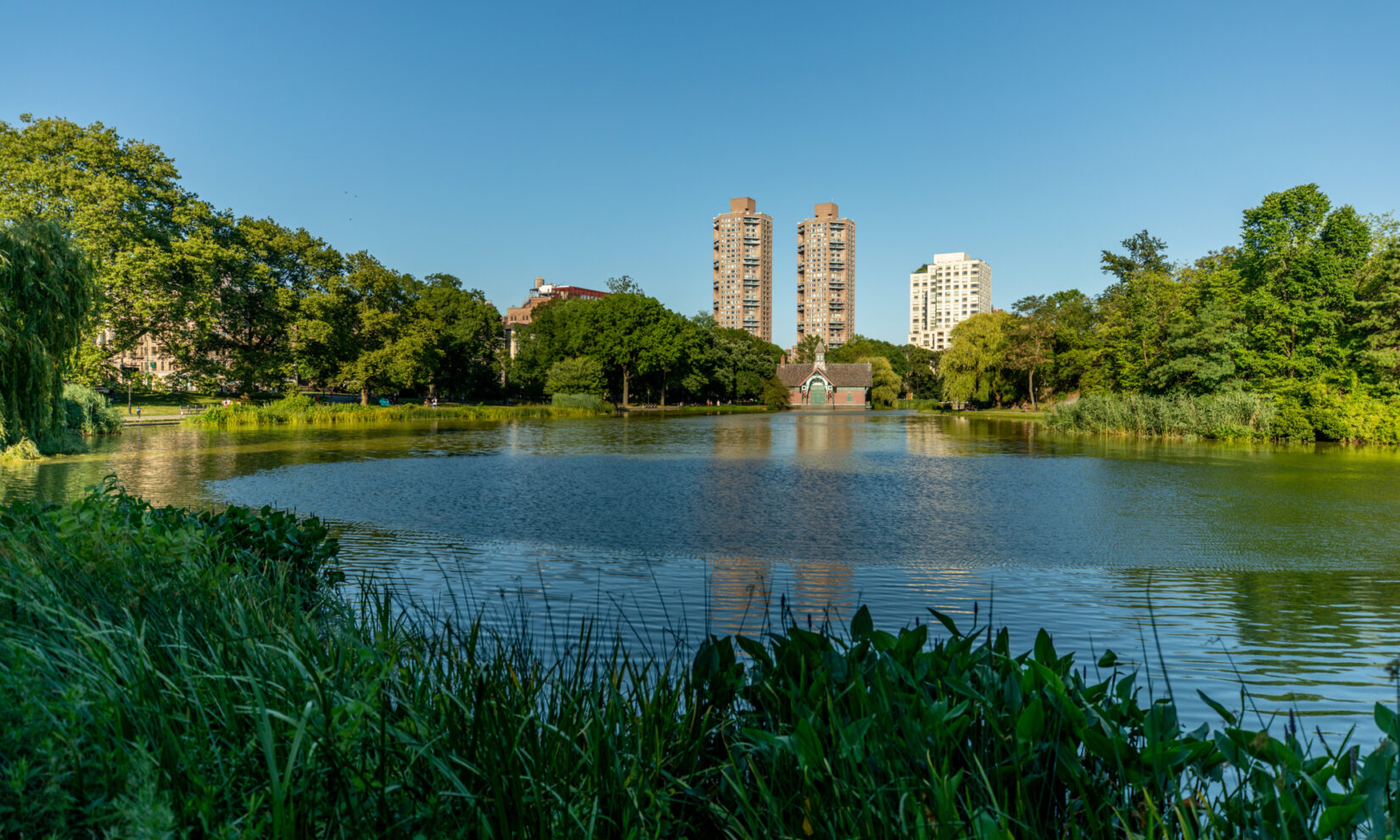 A view across the expanse of the Meer, encircled by green trees, with the Dana Center on the far shore.