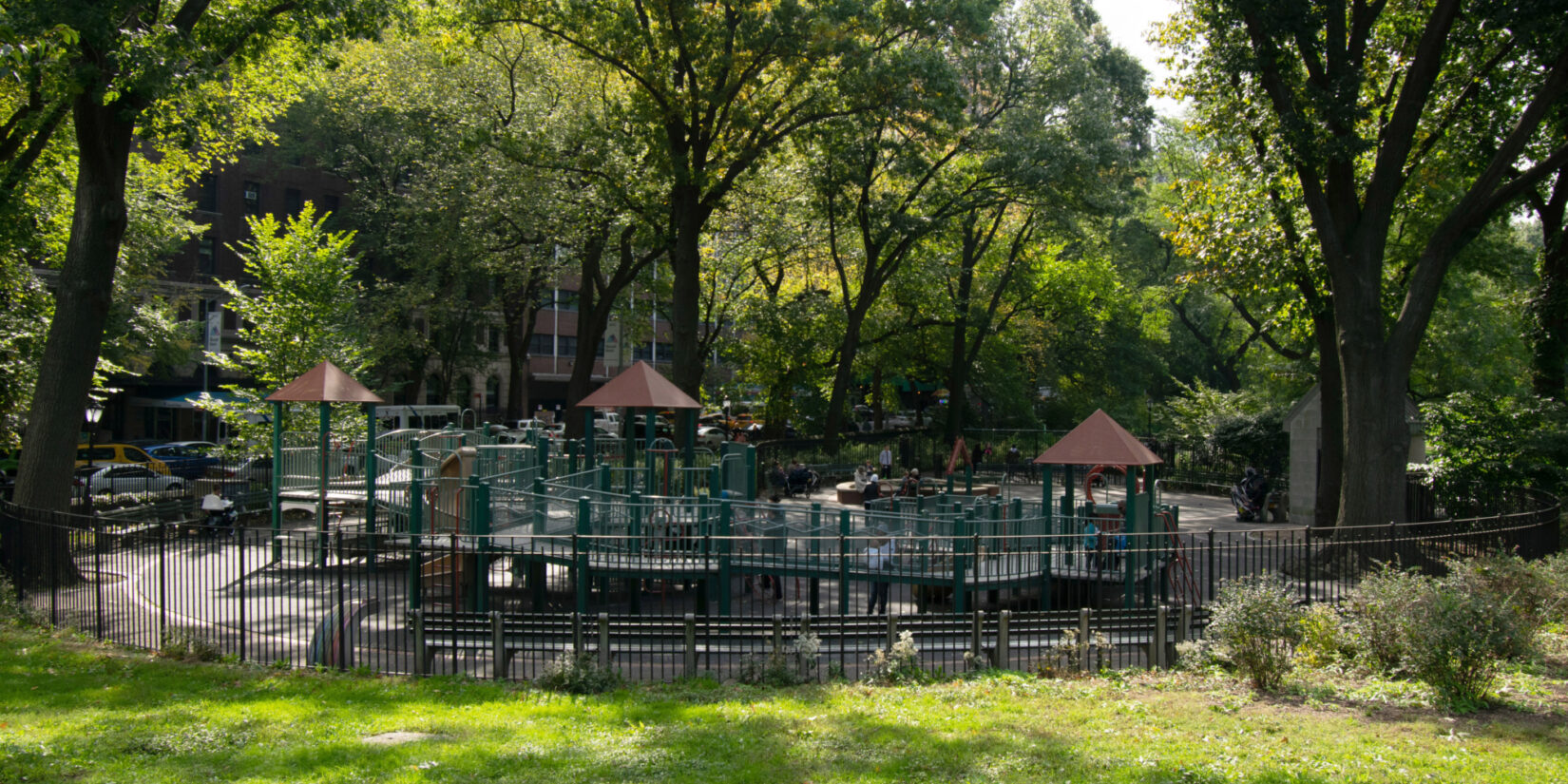 The playground shown in summer, dappled by sunlight