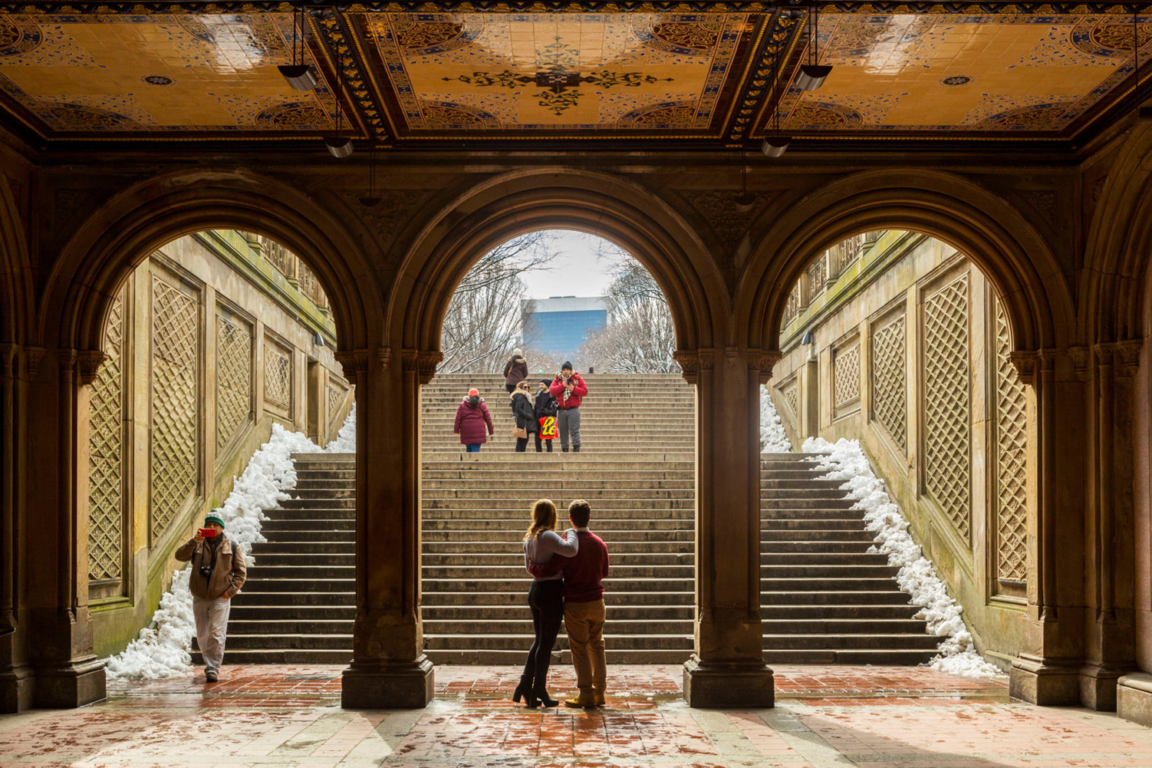 A couple together under the Arcade at Bethesda Terrace.