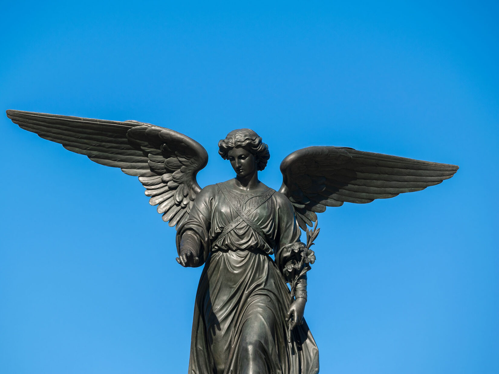 A close-up view of Our Lady of the Water silhouetted by a blue sky