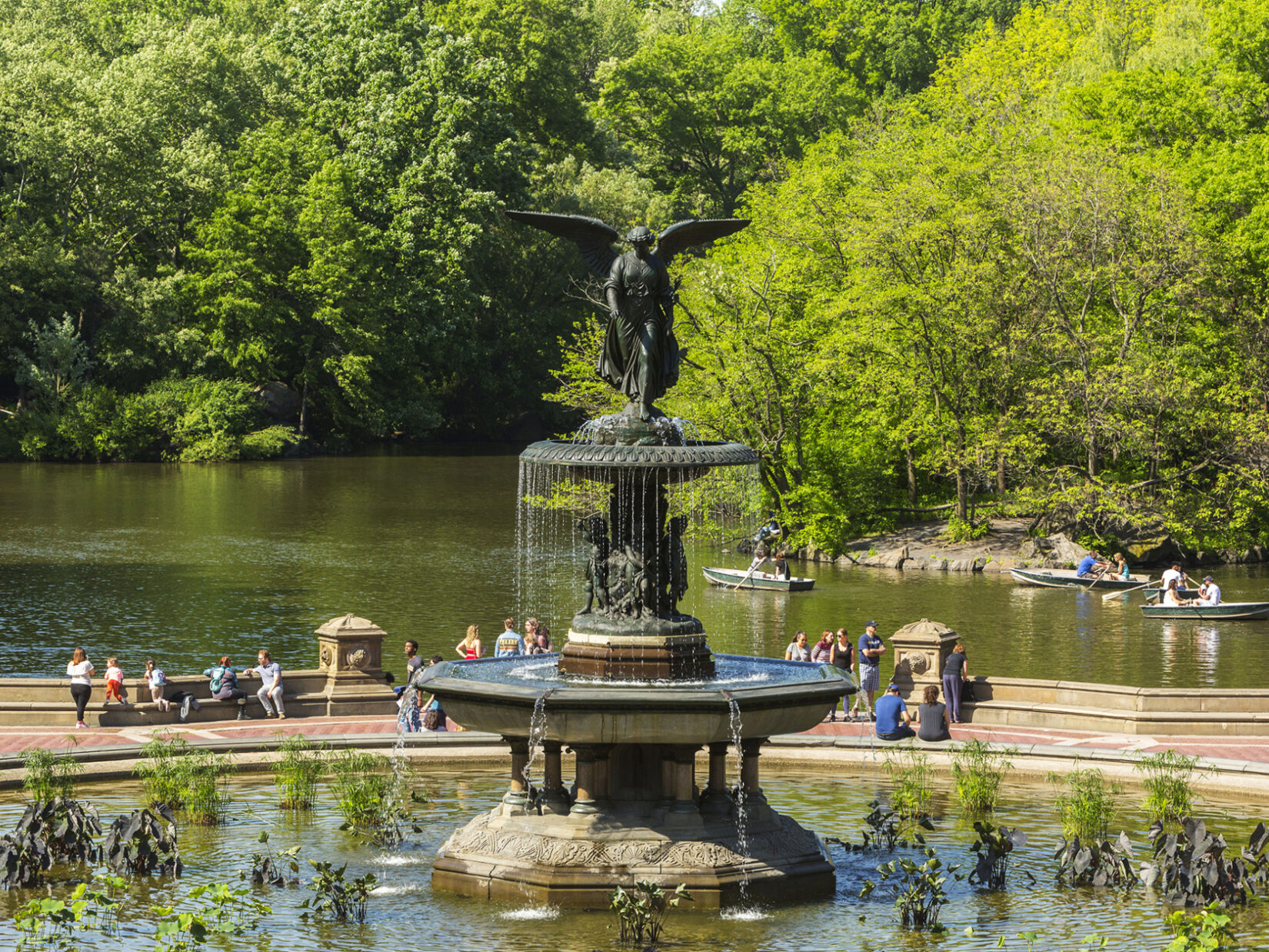 Bethesda Fountain with parkgoers behind it and boaters on the Lake behind them