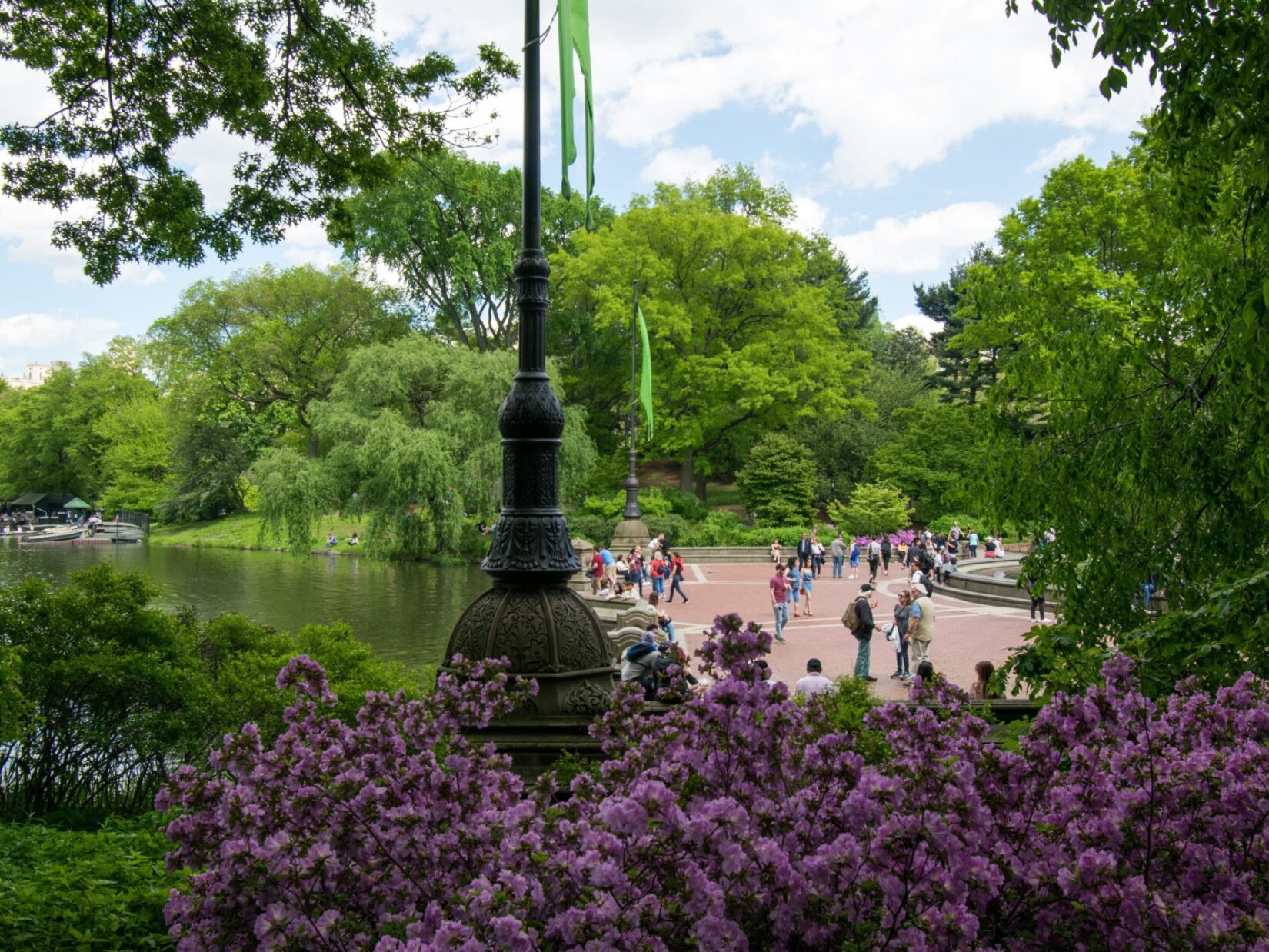 Visitors on Bethesda Terrace seen through a thicket of trees