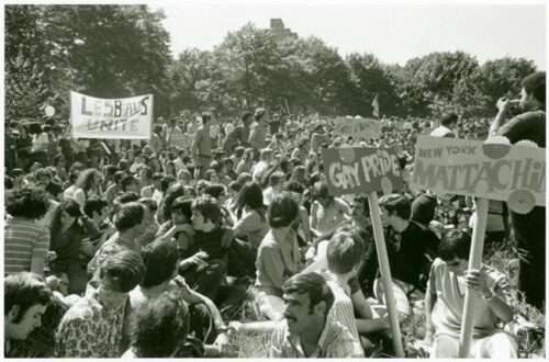 A black and white image of people gathered in Central Park with gay pride signs.