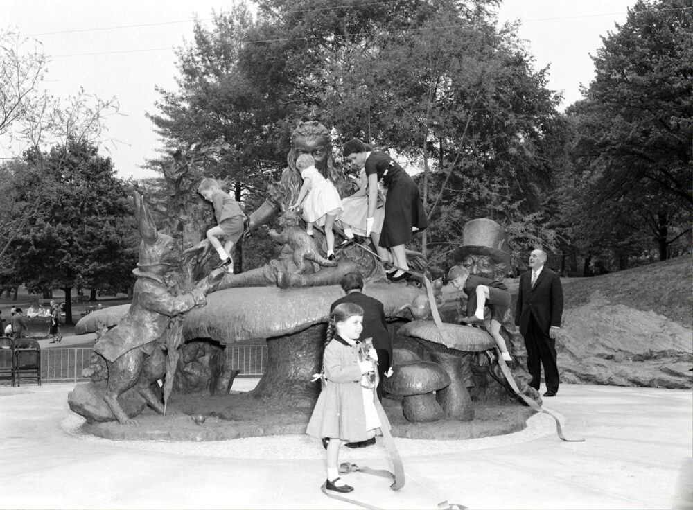 Historical photo of kids climbing on the Alice in Wonderland statue