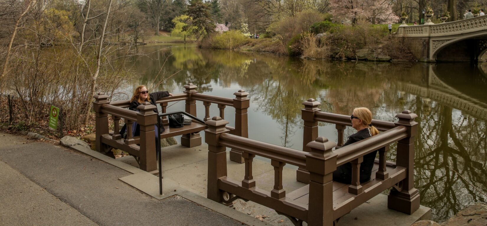 Two women chat on opposite benches on the Landing