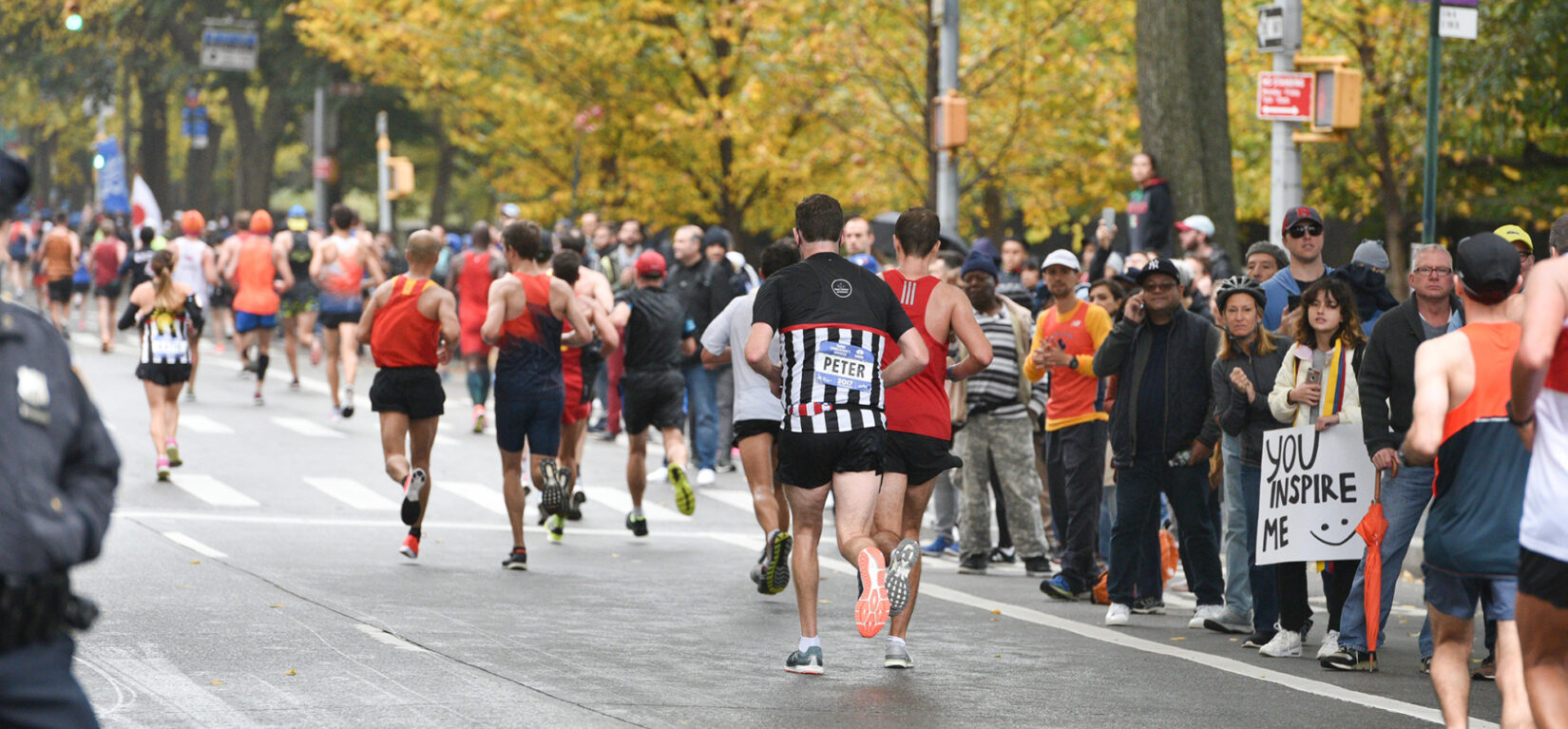 Runners on the roadway with crowds cheering them on