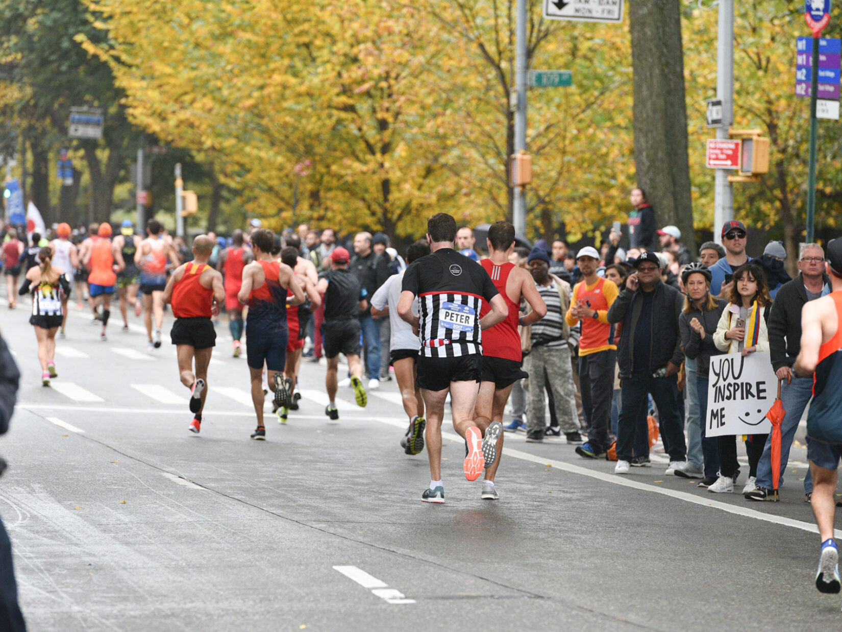 Runners on the roadway with crowds cheering them on