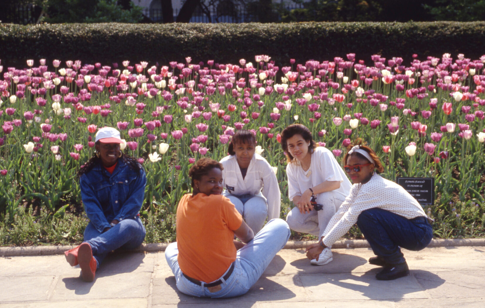 Five young women crouching and sitting on a path in the Garden