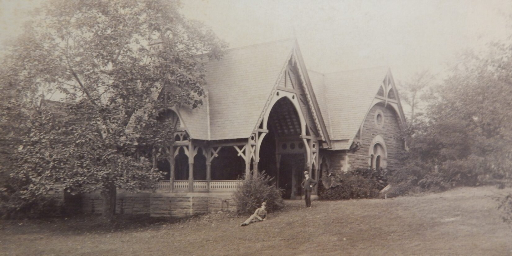 An antique photo of the Dairy with two gentlemen in bowler hats in the foreground