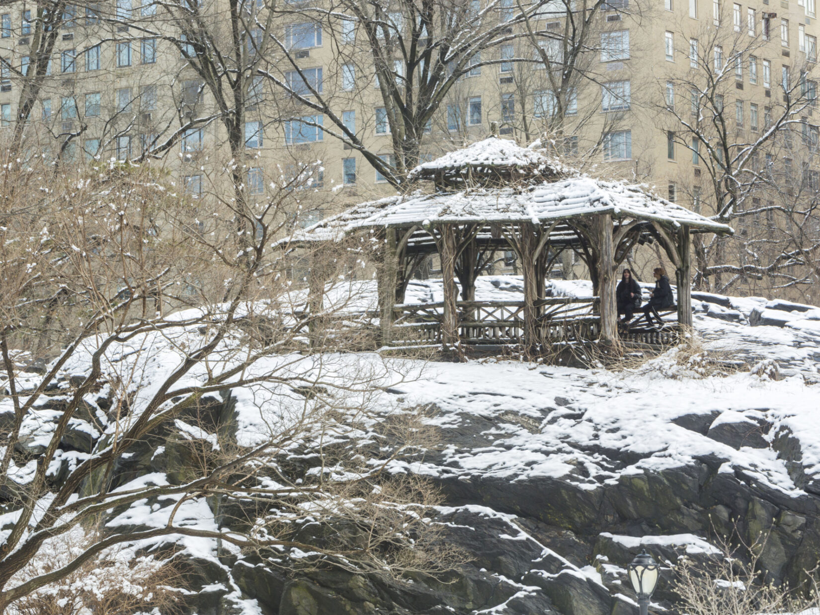 The Shelter is pictured dusted with snow with two parkgoers enjoying its shelter