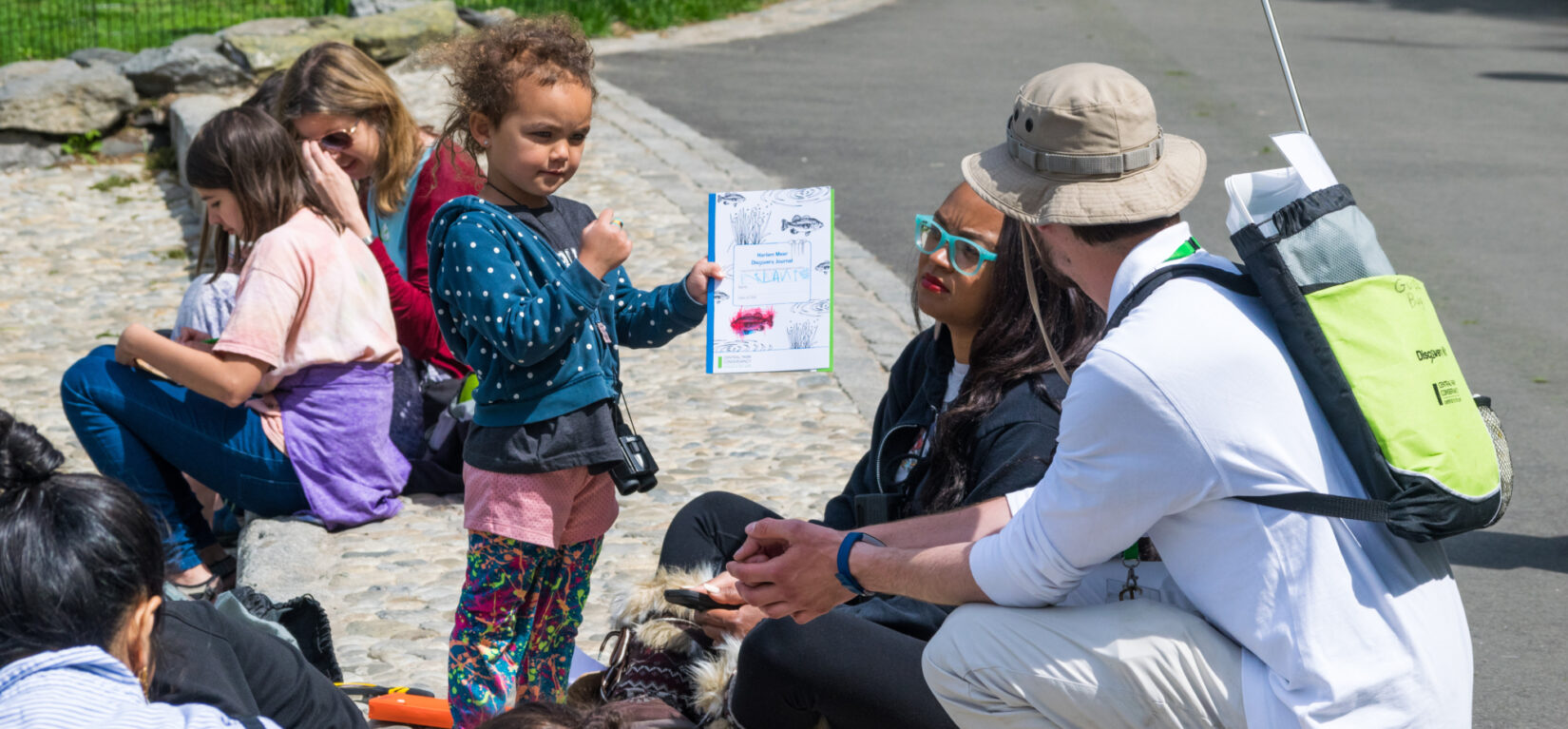 A young girl shows her work to a Park guide