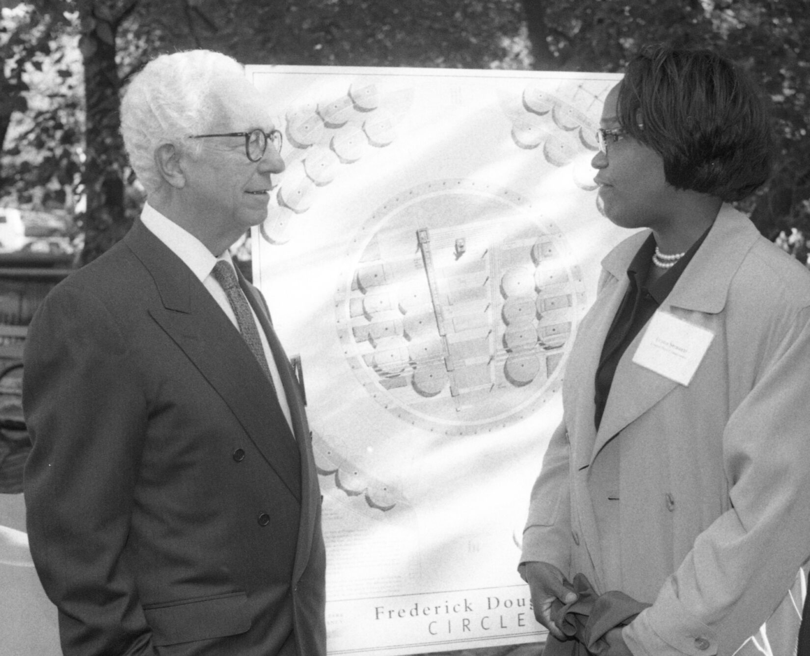 Black-and-white photo of Conservancy leaders in front of a drawing of the proposed circle