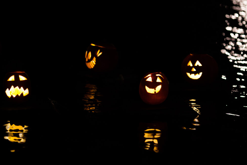 Pumpkins, lit from within, floating on the Meer at night