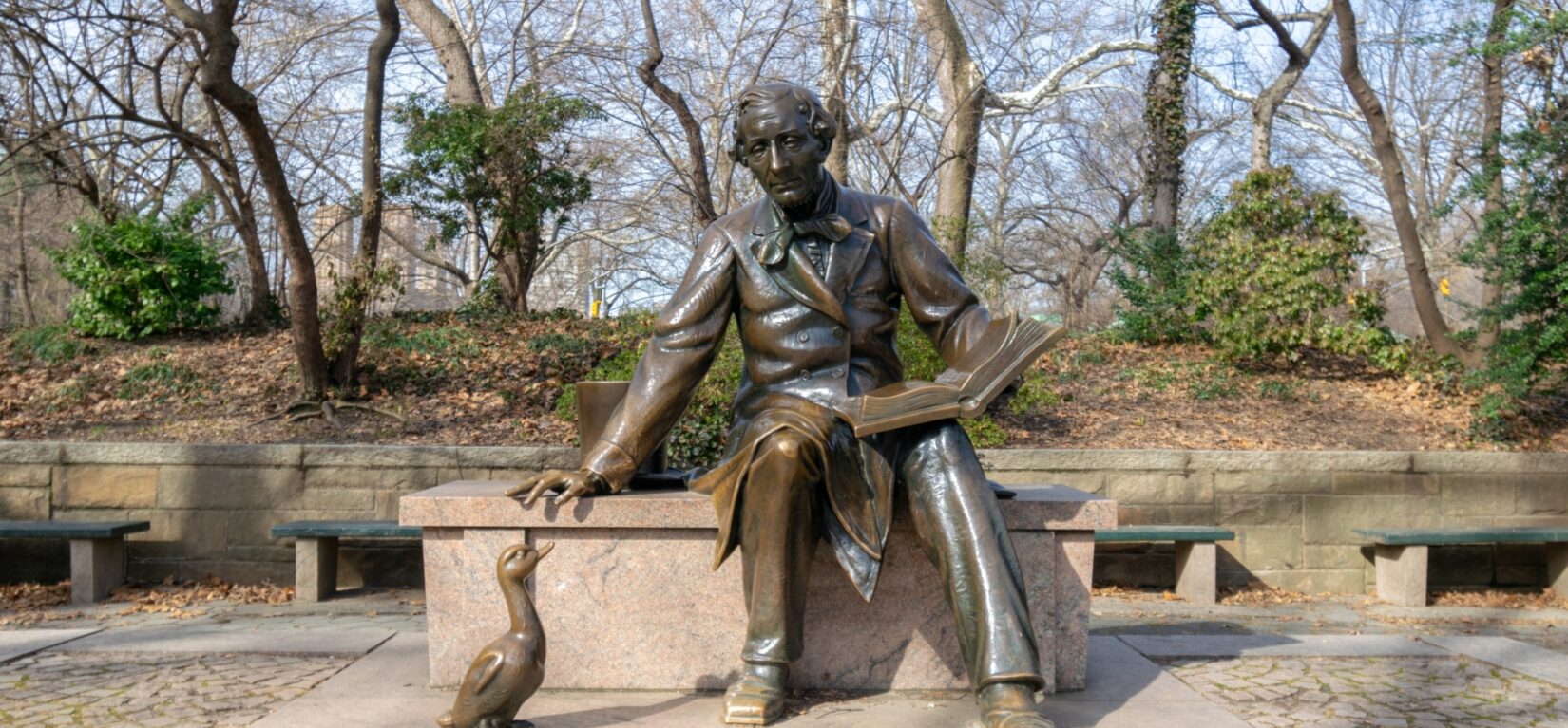 The sculpture of the author is viewed by a sculpture of an ugly duckling