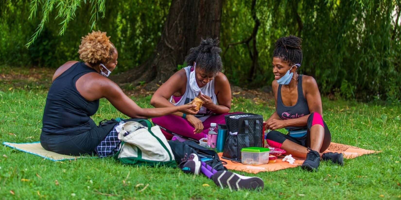 Three women enjoying a picnic on blankets at the Meer.