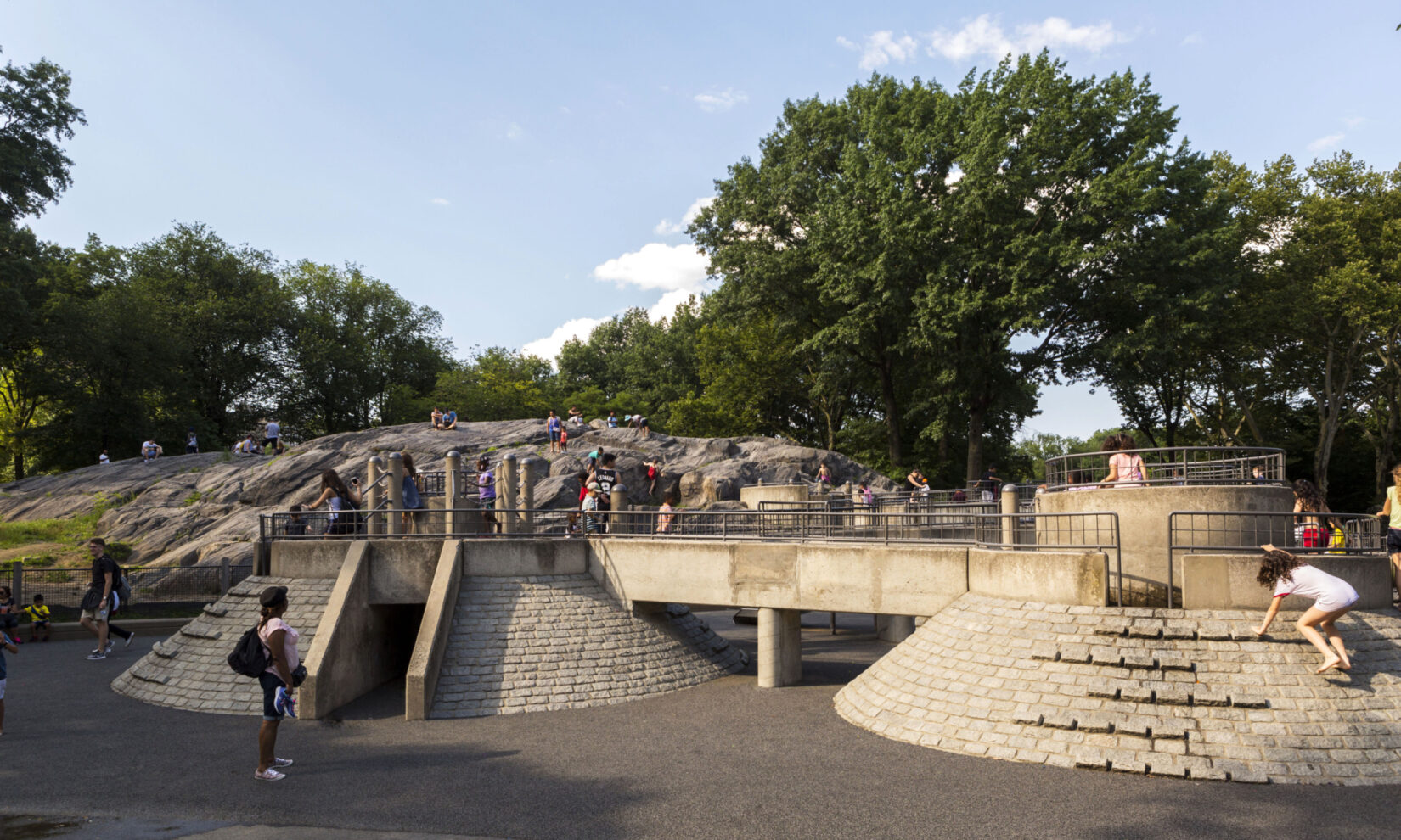 The natural rock outcropping in the background is as much a part of the playground as the bridged climbing areas in the foreground.