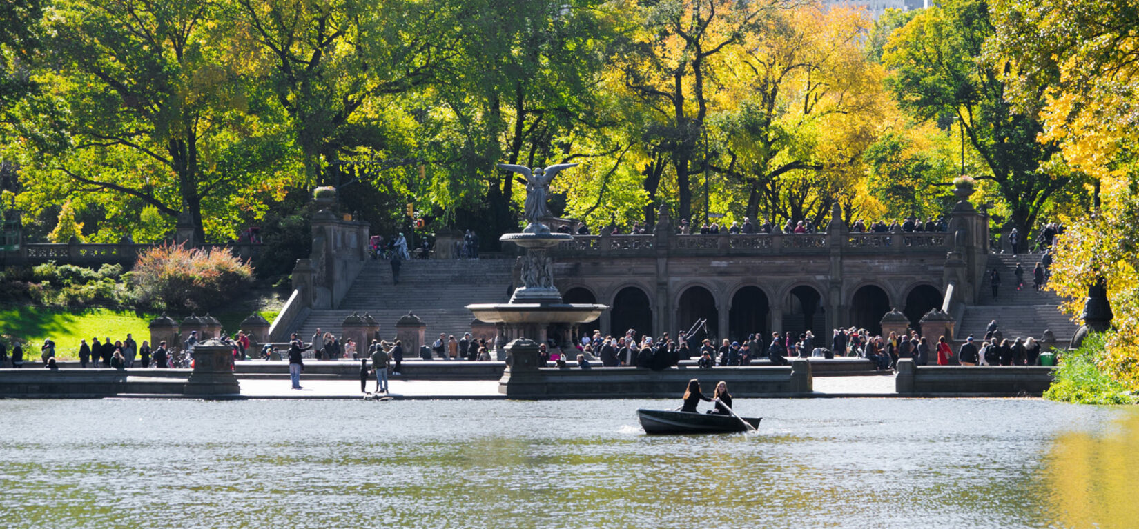 Looking across the Lake to Bethesda Terrace thronging with parkgoers