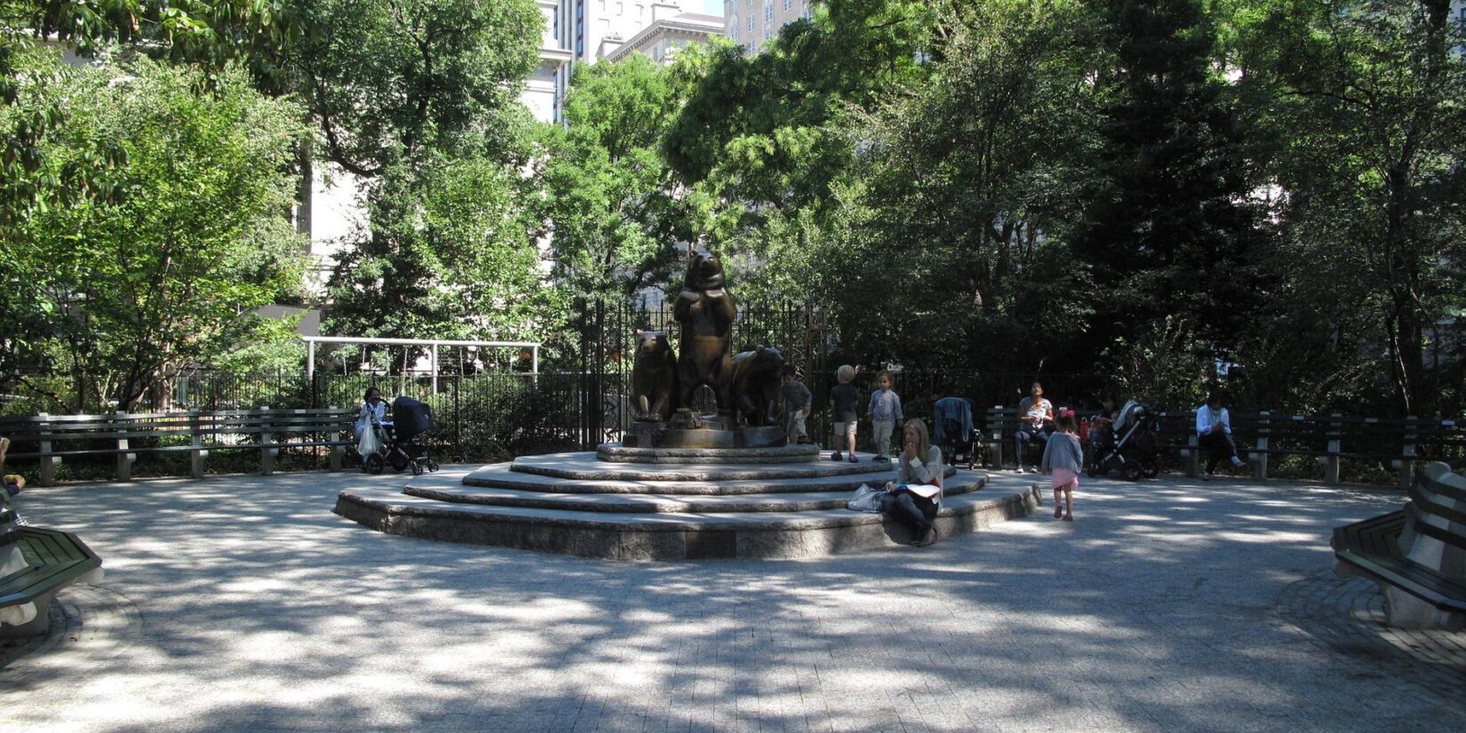 The circular plaza provides bench seating with the statue at the center.