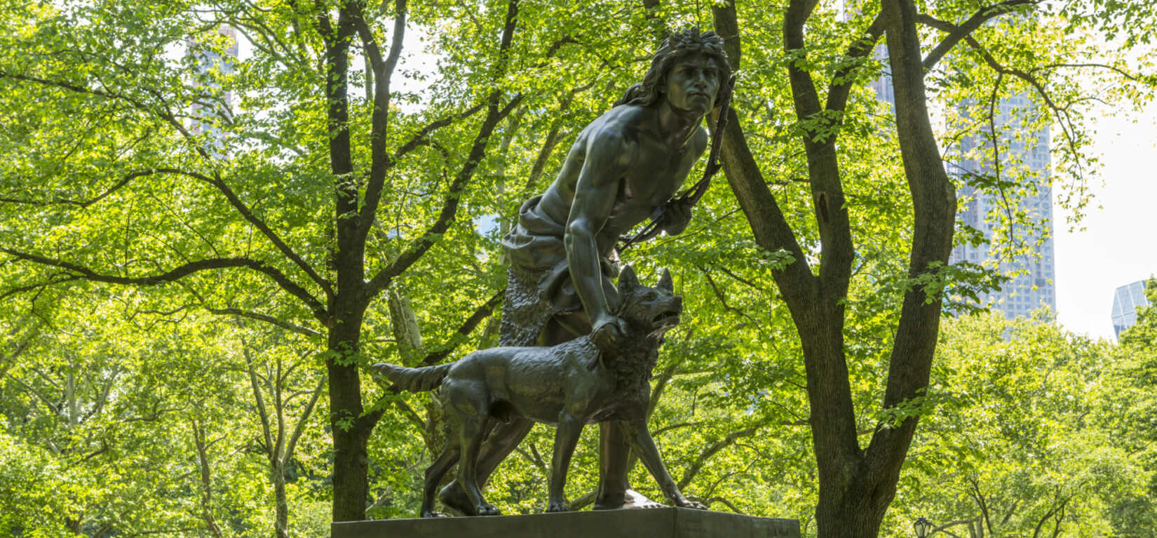 The statue with fresh spring leaves in the background