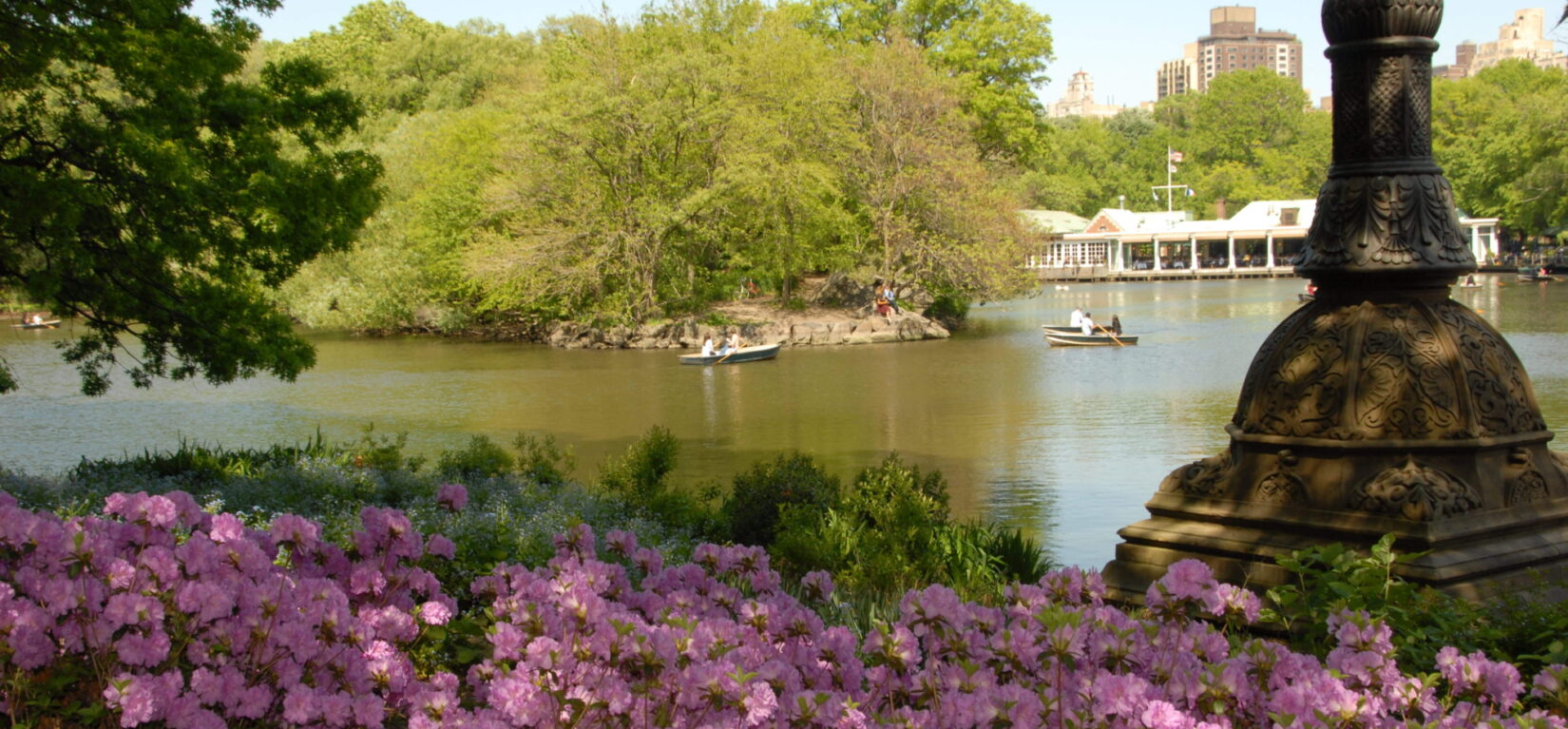 Boaters on the lake with the Boathouse in the distance