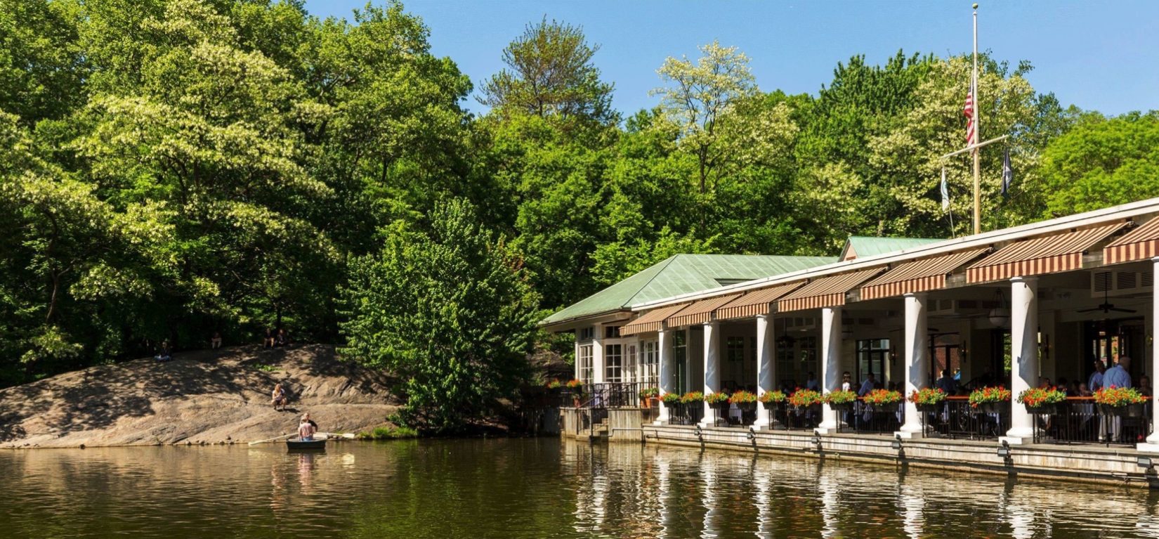 The boathouse is seen reflected in the waters of the Lake.