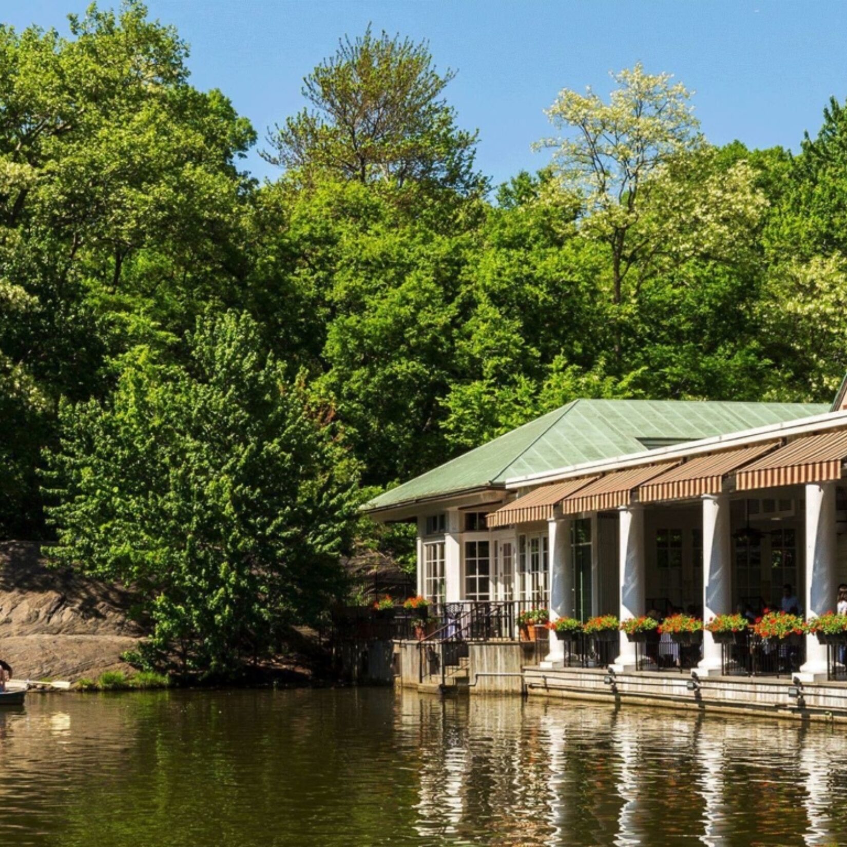 The boathouse is seen reflected in the waters of the Lake.