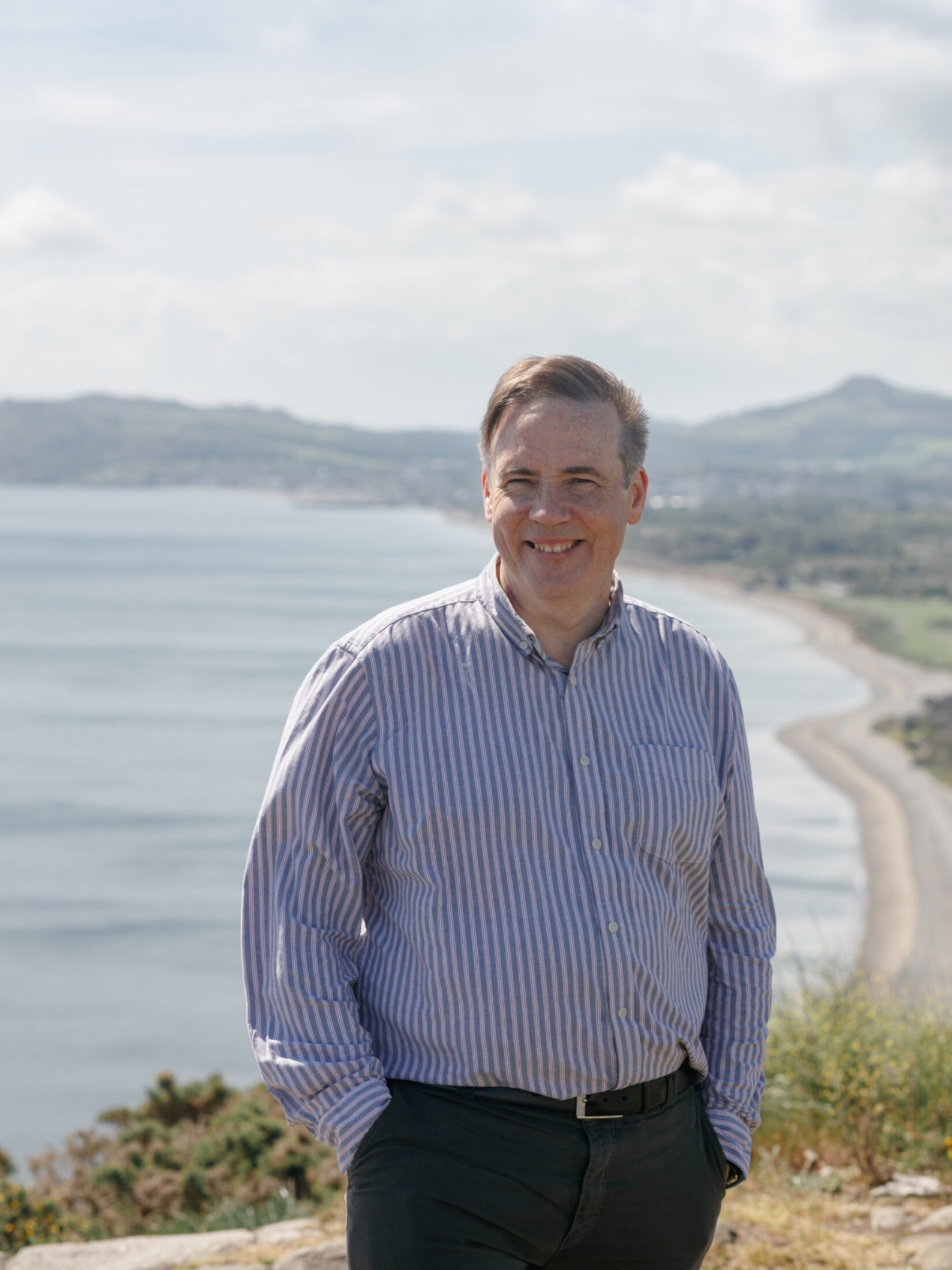 Portrait image of Shane O'Mara, photographed overlooking a beach