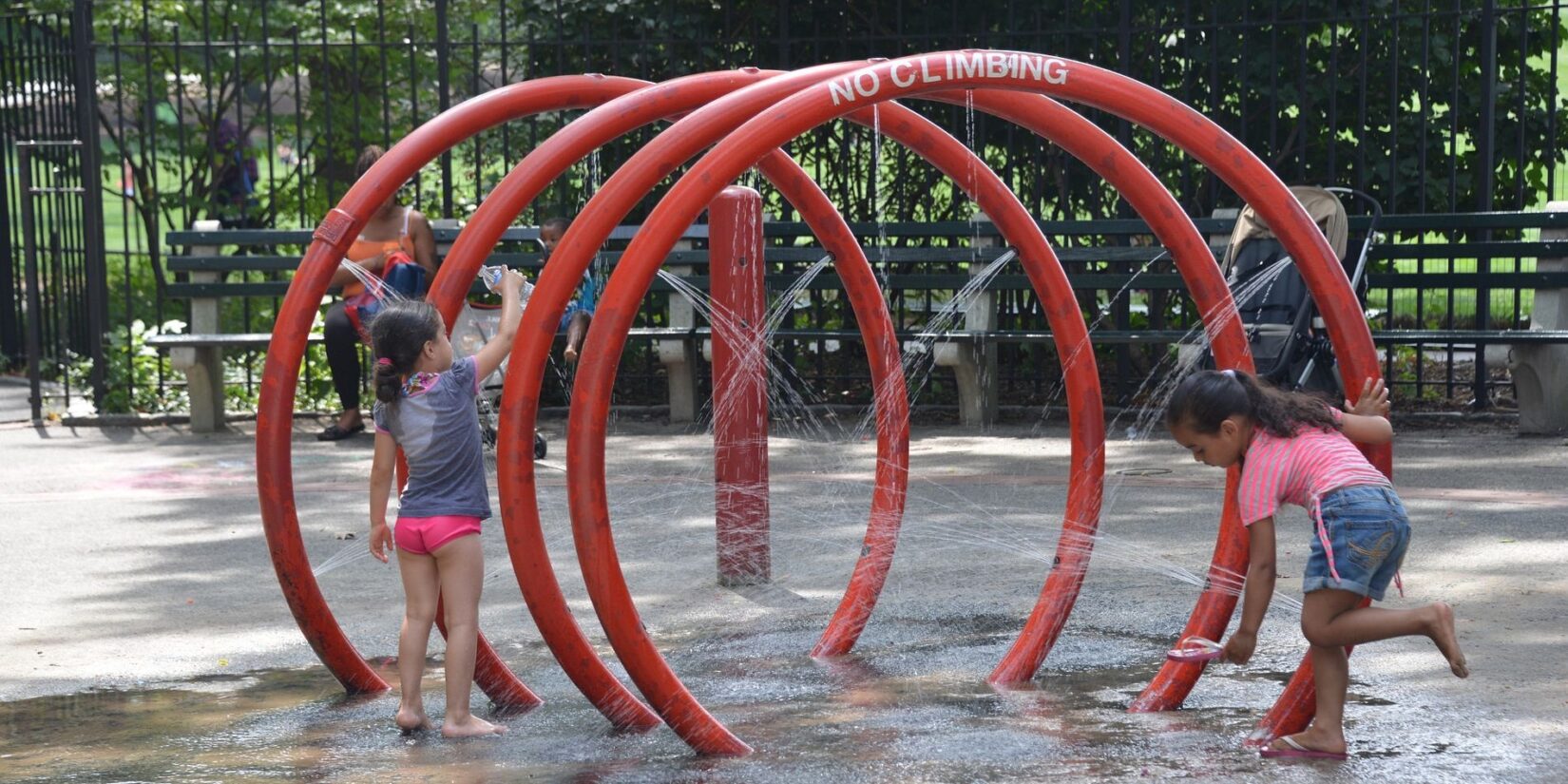 The water feature resembles a red coil large enough for small children to run through the center.