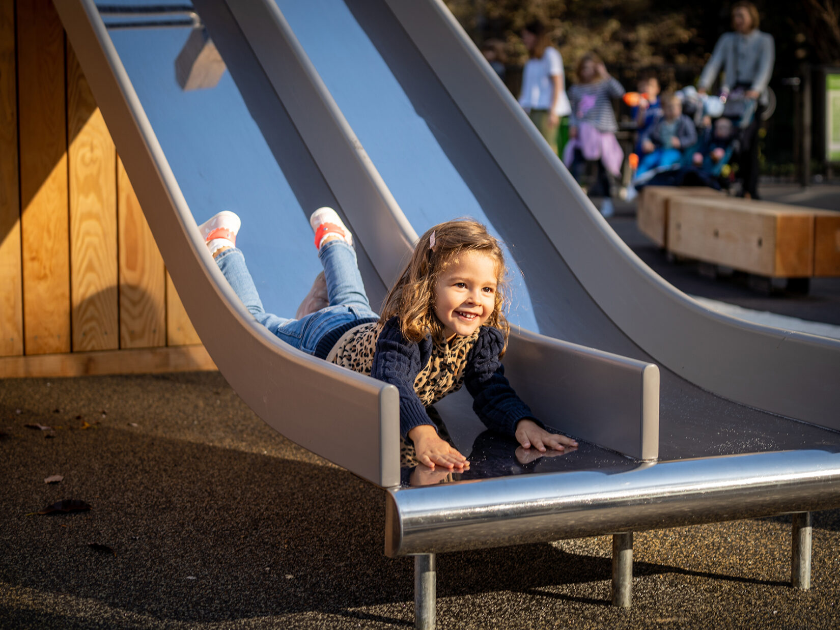 A little girl has slid head-first down a sliding pond