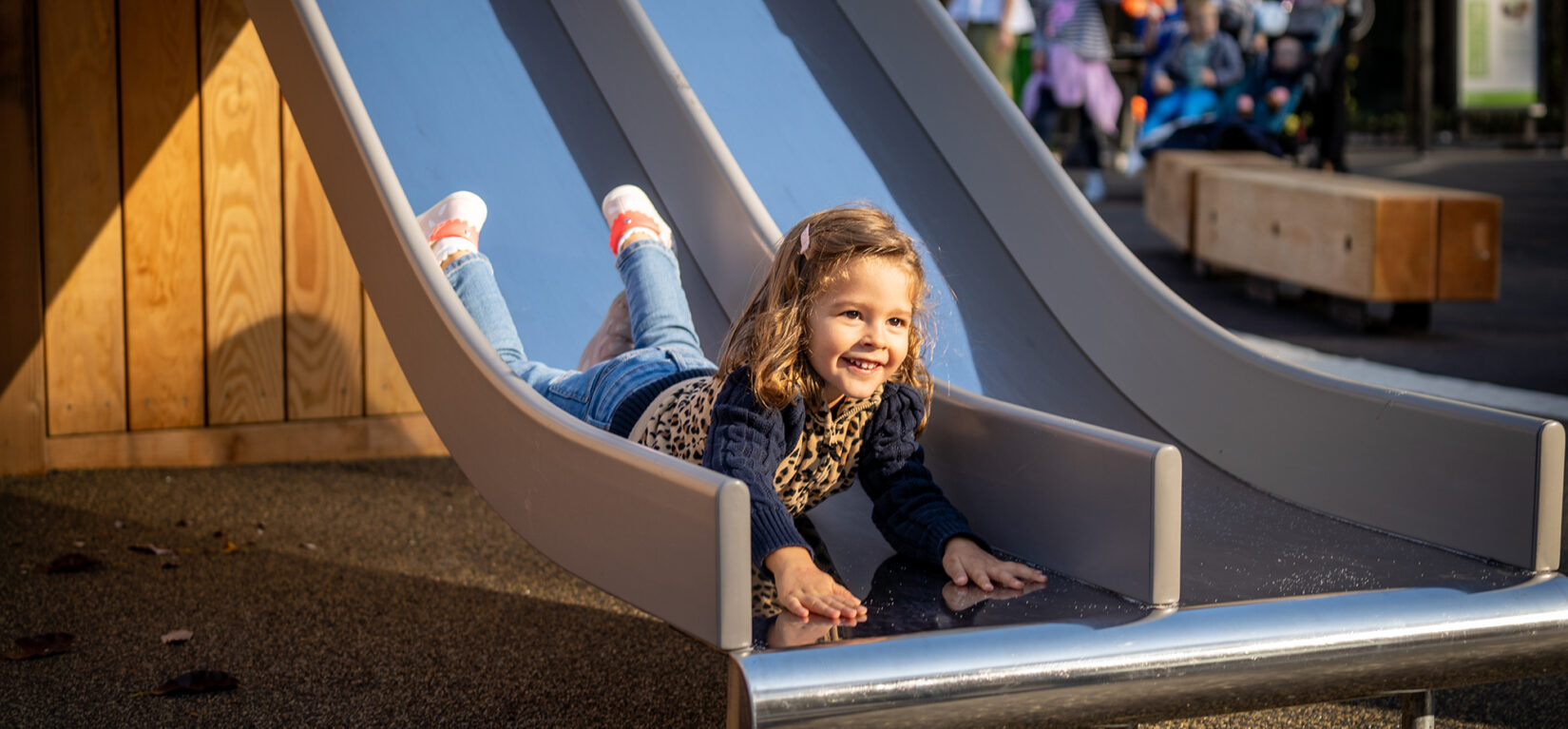 A little girl has slid head-first down a sliding pond