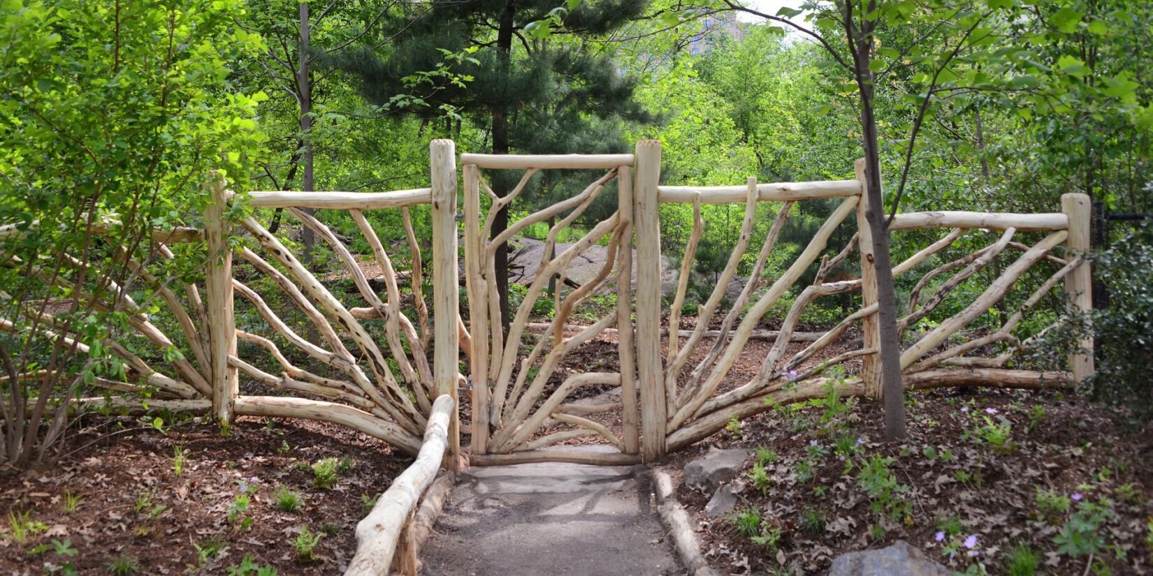 The rustic gate with spring trees behind it.