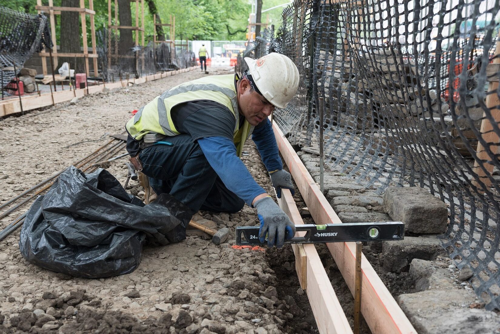 A Conservancy worker checking if the boards of a concrete form are level