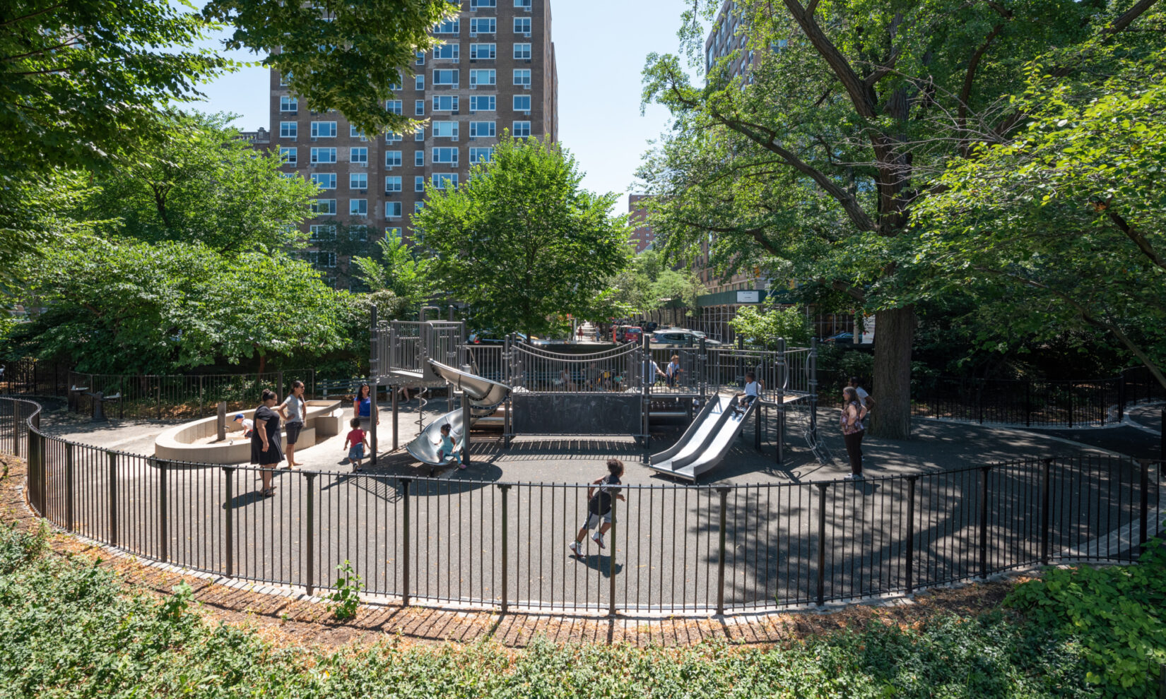 Children enjoying the sliding ponds under a bright summer sun.