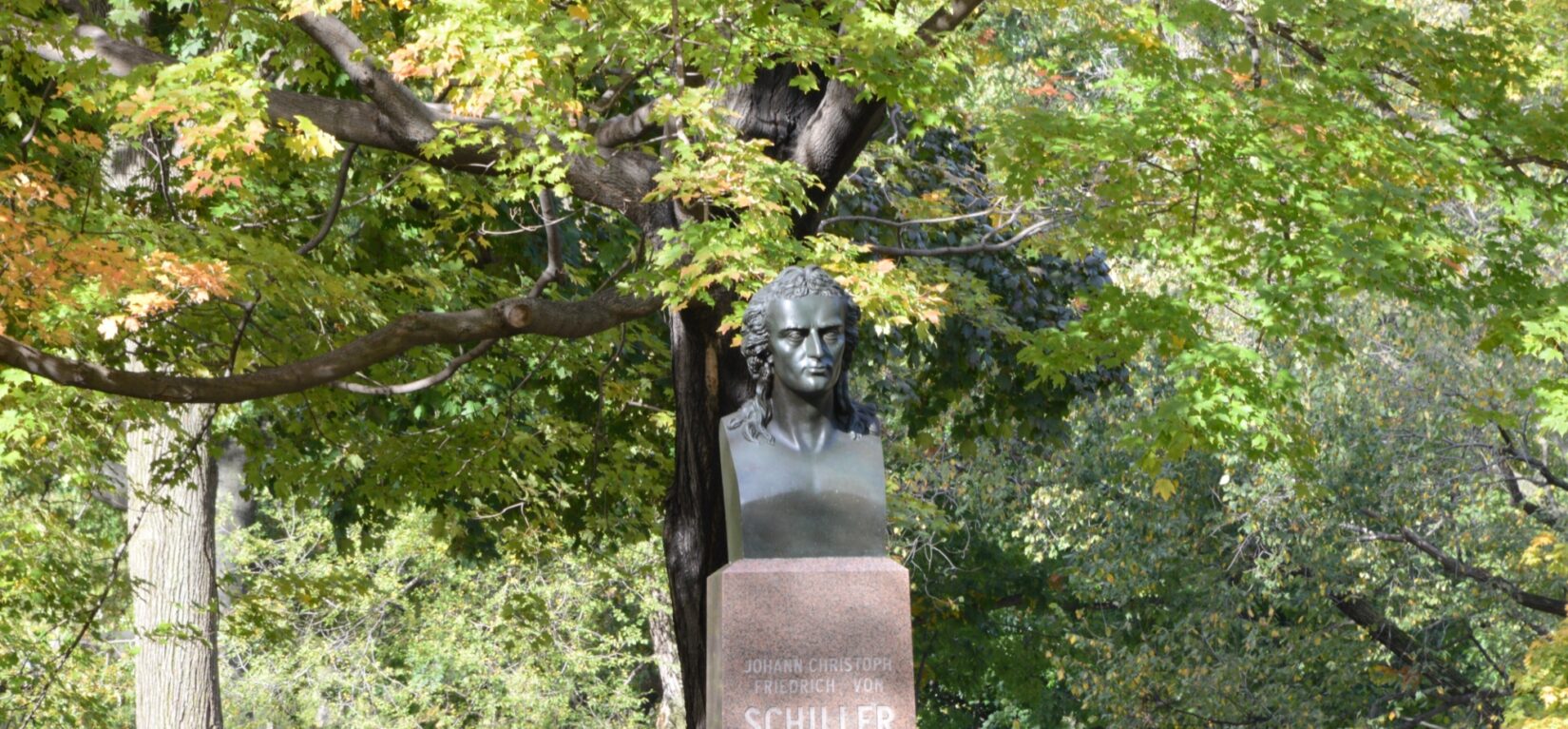 The bust of Schiller, on its pedestal, beneath the spreading branches of a tree