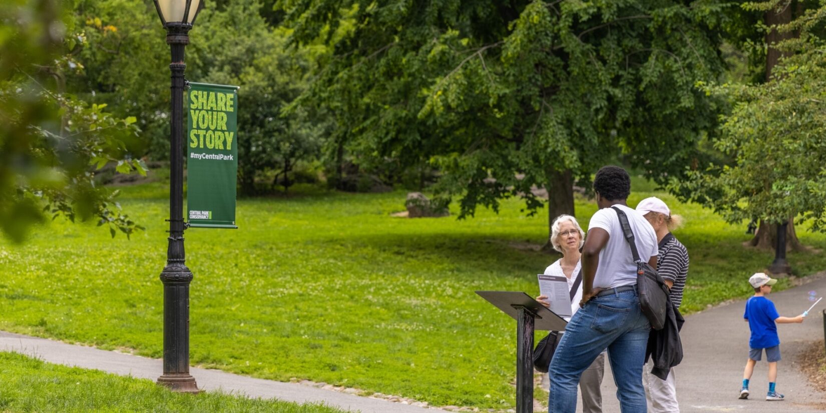 Park-goers pause at on-site signage to learn more about Seneca Village.