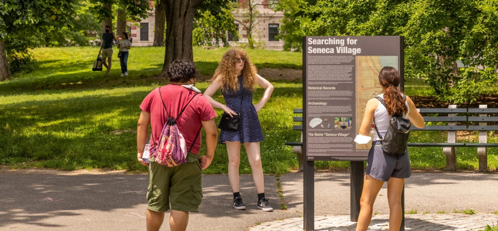 Park visitors reading signage at the Seneca Village site.