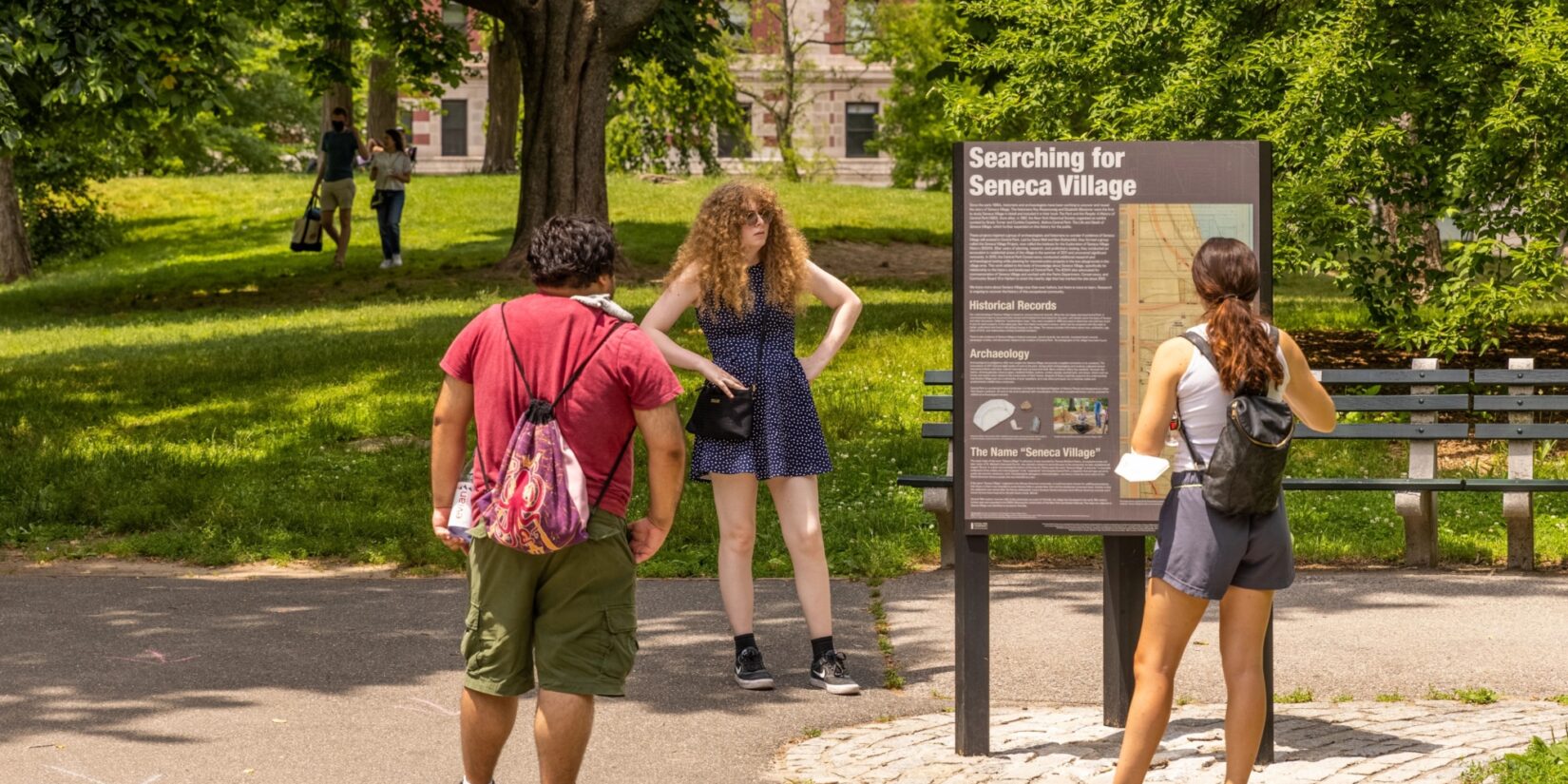 Park visitors reading signage at the Seneca Village site.