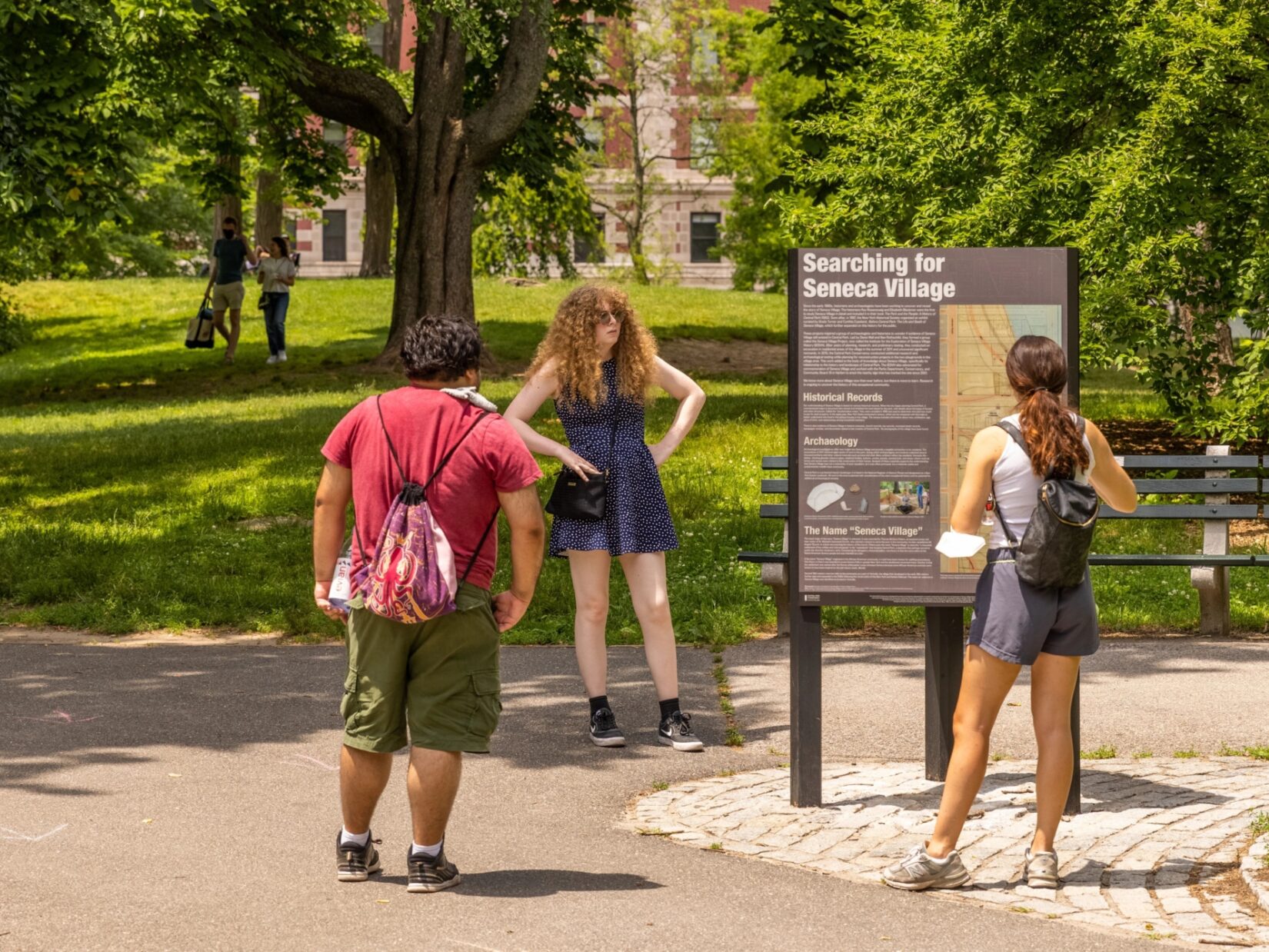 Park visitors reading signage at the Seneca Village site.