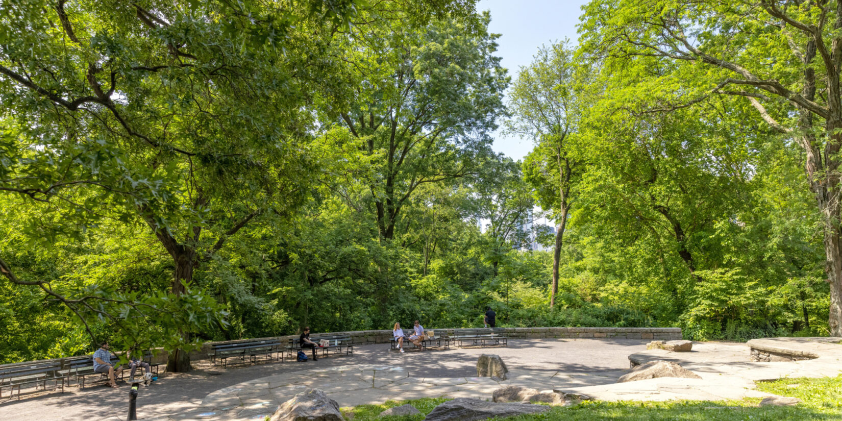 Park visitors sit on benches near Summit Rock in Seneca Village