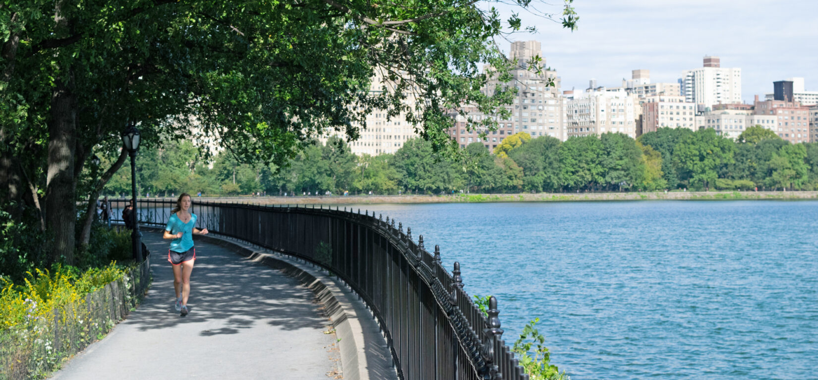 A woman jogs around the Reservoir on the Shuman Running Track