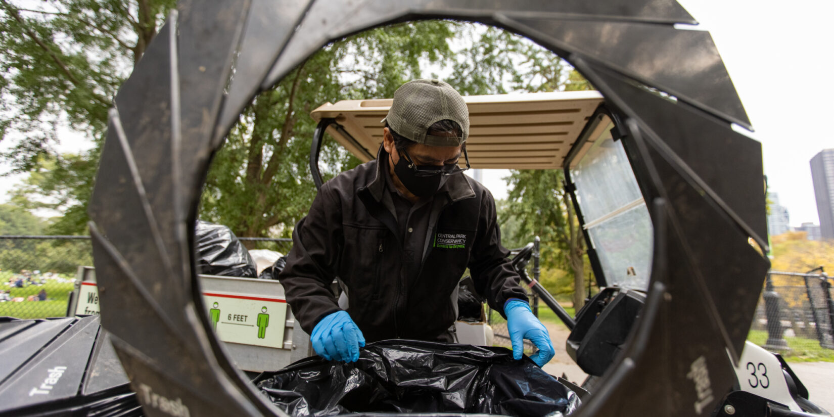 Staff member Danila Maturan photographed through the open lid of a trash can.