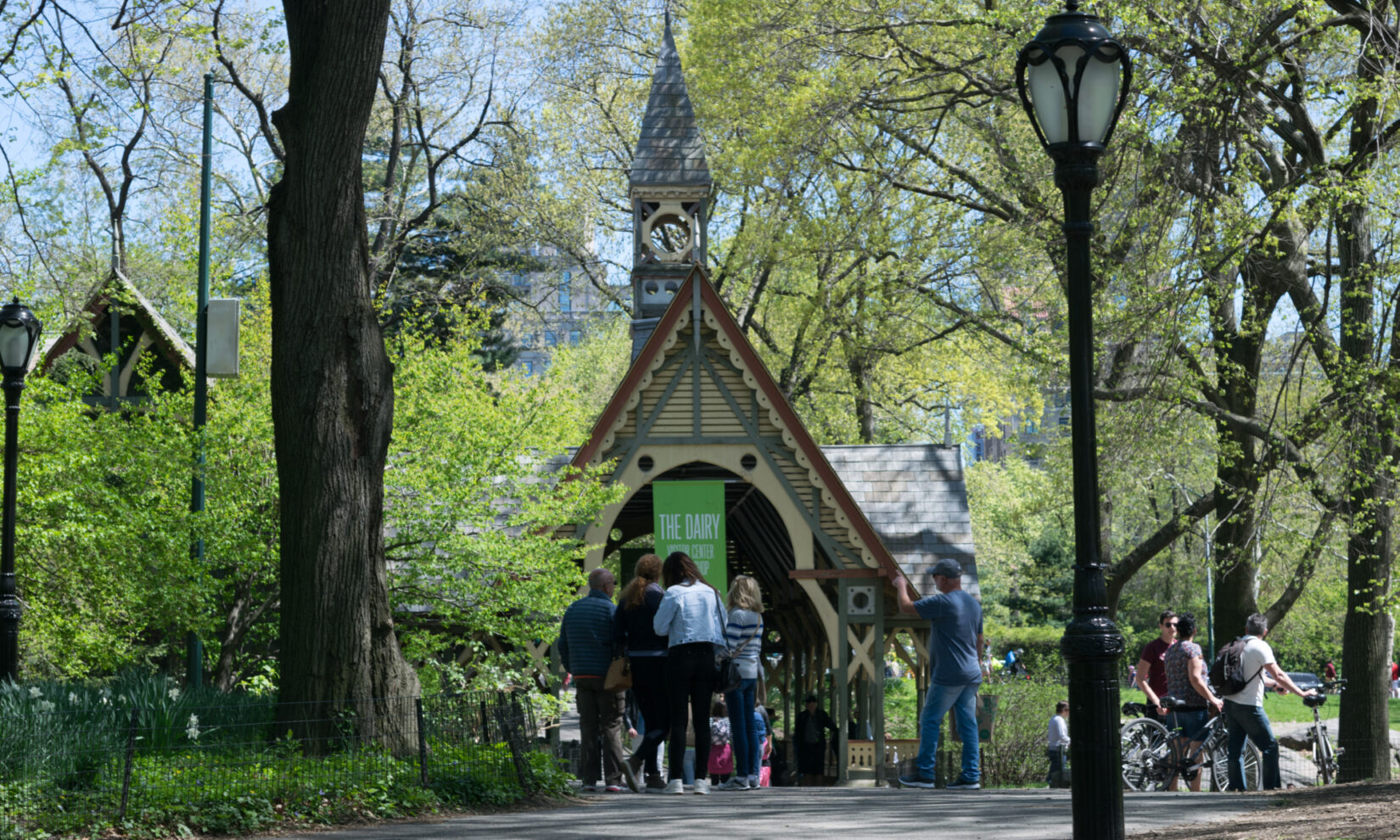 Park-goers congregate in dappled spring sunlight outside the Dairy