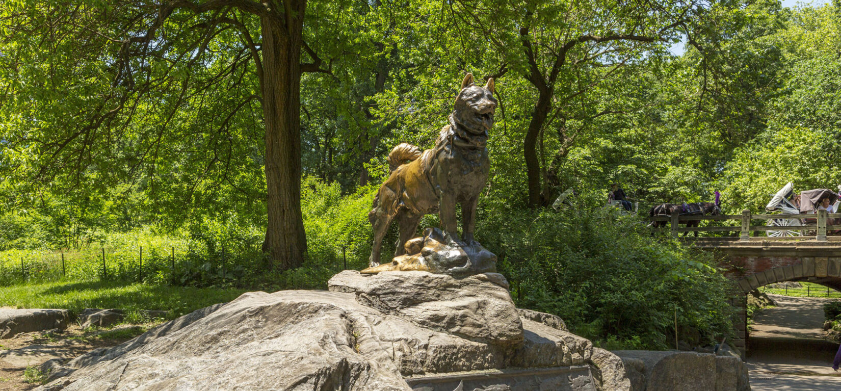 A photograph of the statue perched on an outcropping and the accompanying plaque