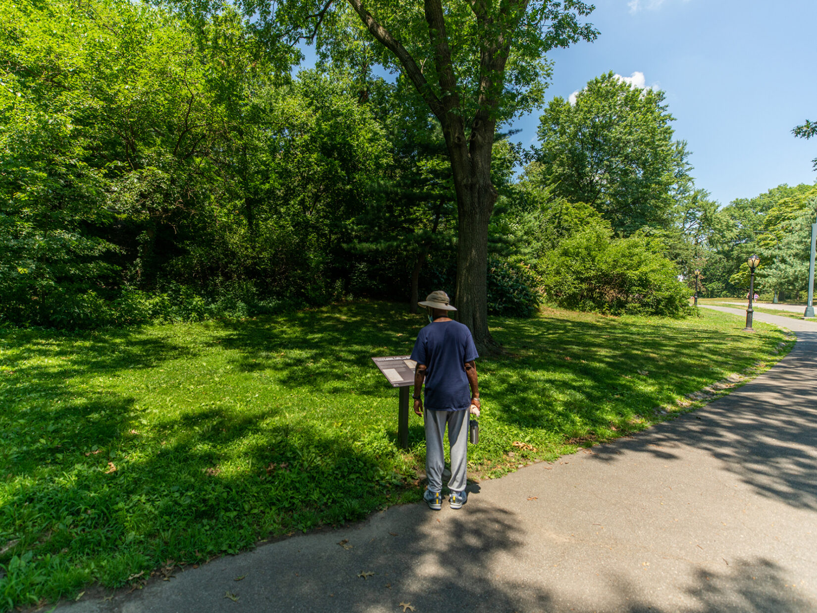 Park visitor reading Discover Seneca Village signage