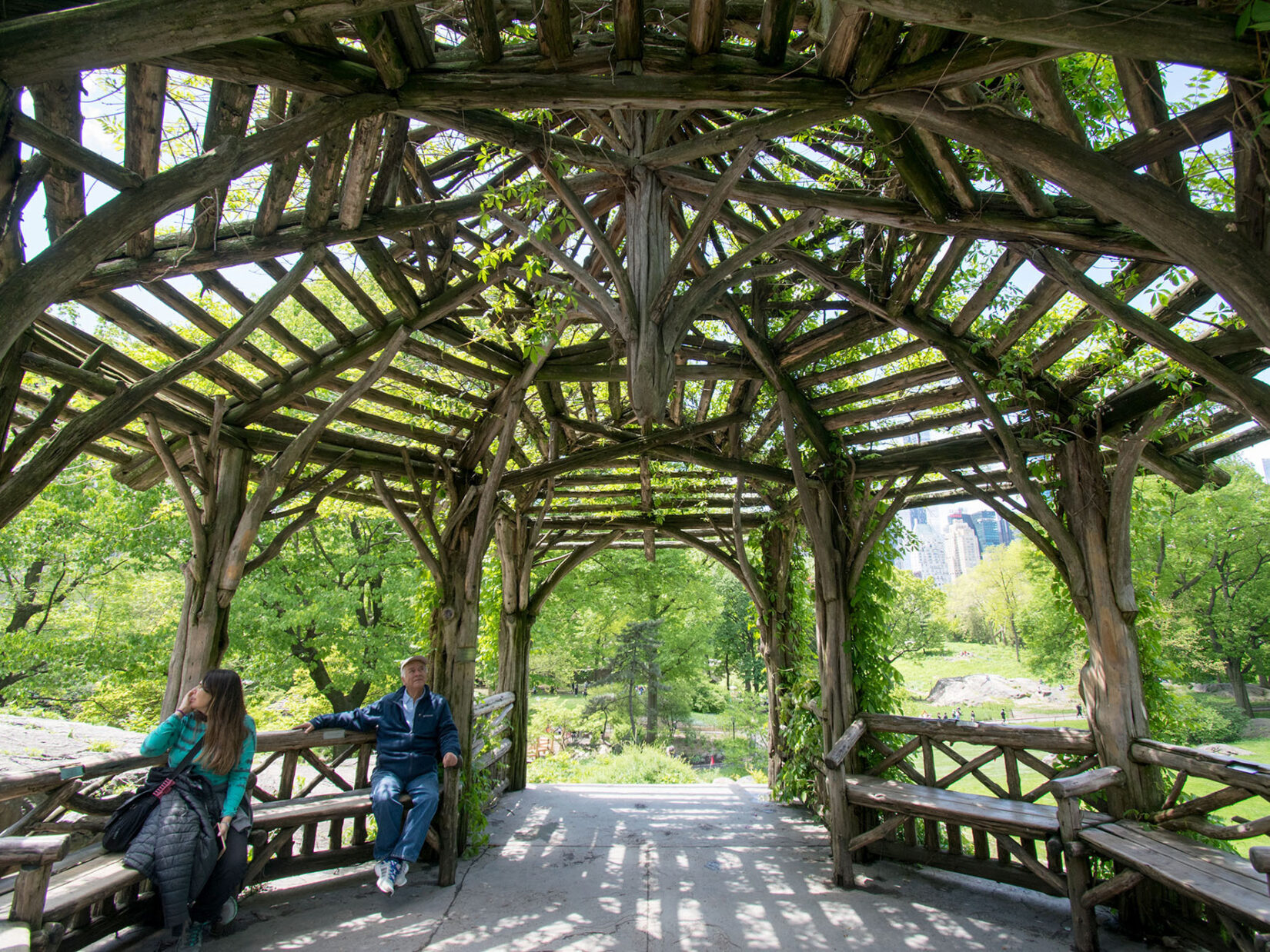 The roof of the rustic structure is a dramatic frame for two visitors seated below